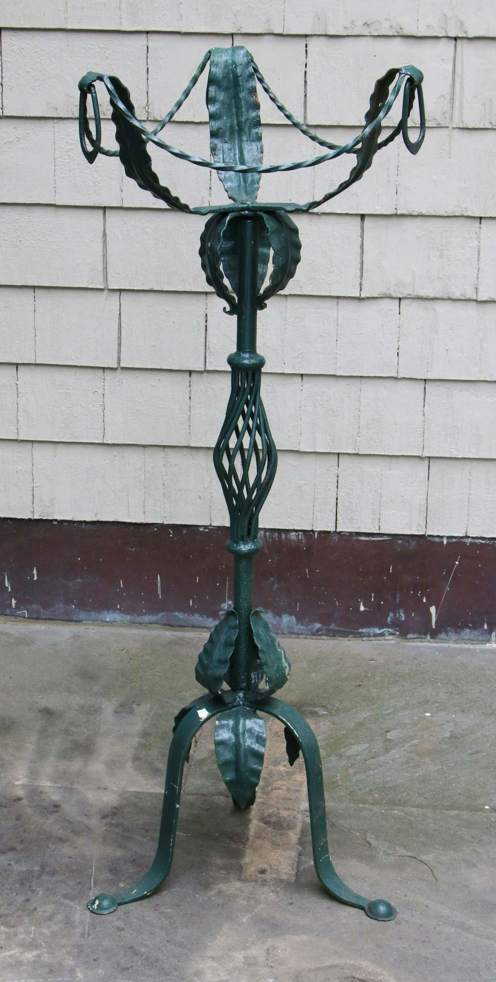 Wrought iron plant stand: Wrought iron plant stand with leaf decoration. Some misshaping. 46-1/2''h.