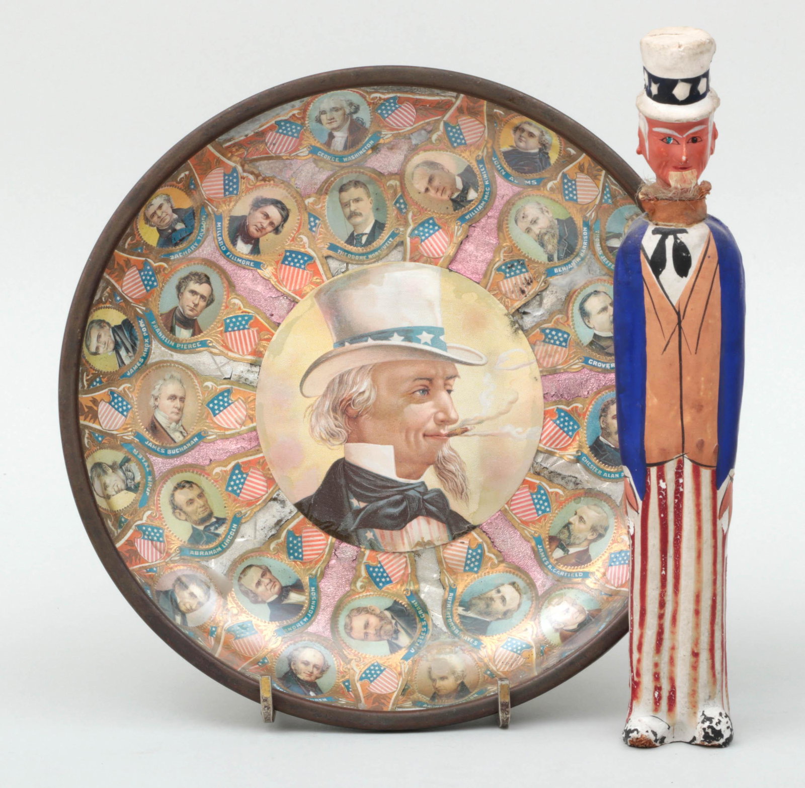 Group of (2) Uncle Sam items: Group of (2) Uncle Sam items, to include: ash tray with cigar wrapper presidential portraits; and Uncle Sam figure with pull up fan. Wear to paint and minor losses to figure. Ash tray 1-1/4''h, 7-3/8'