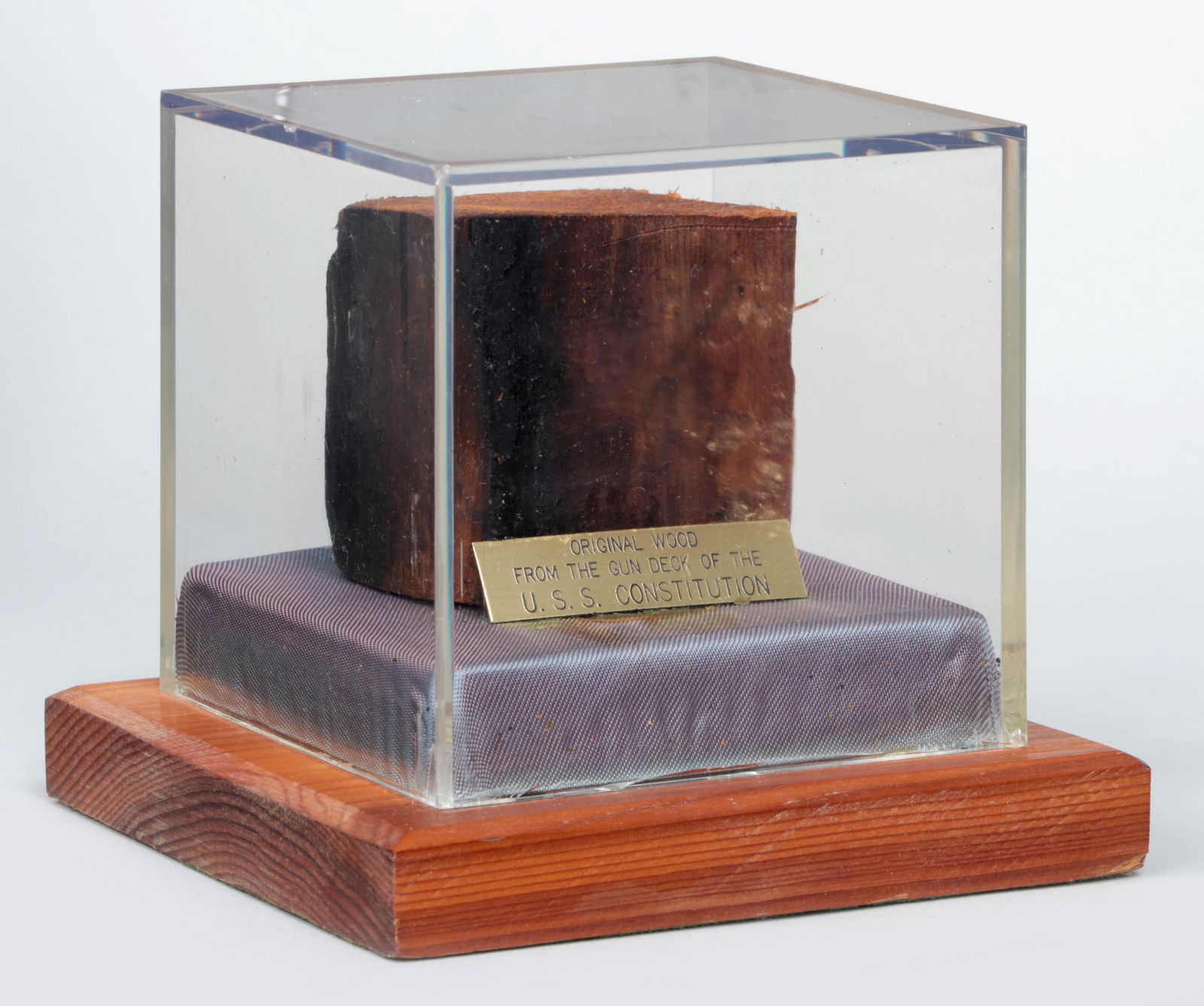 U.S.S. Constitution gun deck: Original piece of wood from gun deck of U.S.S. Constitution. Case 4-1/2''h, 5''w, 5''d. Provenance: Commissioner of Real Property from City of Boston during the 1970s renovation; to present owner by d