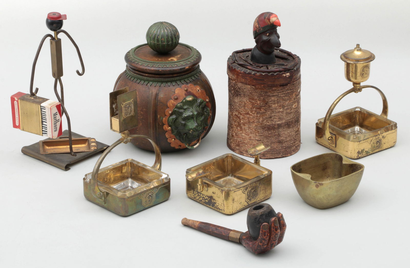 Group of (8) Tobacciana items: Group of (8) Tobacciana items, including: (2) tobacco jars, (repair to one); carved pipe with hand; three-piece Wurttembergische Metallwarenfabrik ash tray set; Hagenauer Werkstatte ash tray; and Blac