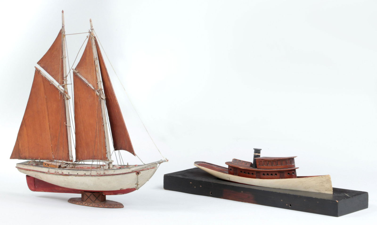 Group of (2) carved wood ship models: Group of (2) carved wood ship models, to include: early steam yacht with wood mount; and early double masted sailboat with carved wood sails. Impact marks on steam yacht and one carved wood sail repai