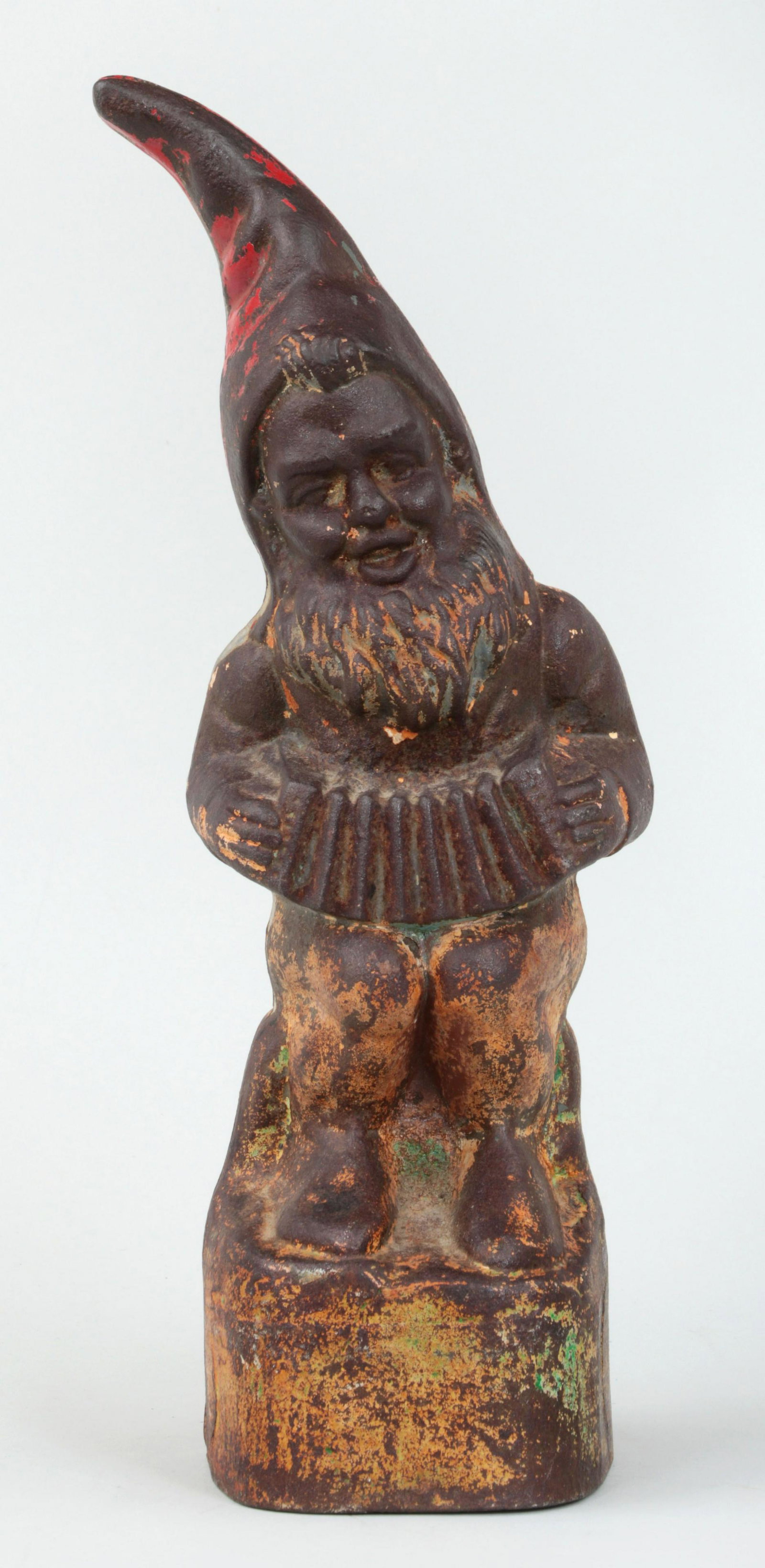 Gnome with accordion: Polychrome painted cast iron doorstop of gnome with accordion. Wear to paint. 13-1/8''h, 5''w, 4-1/2''d.
