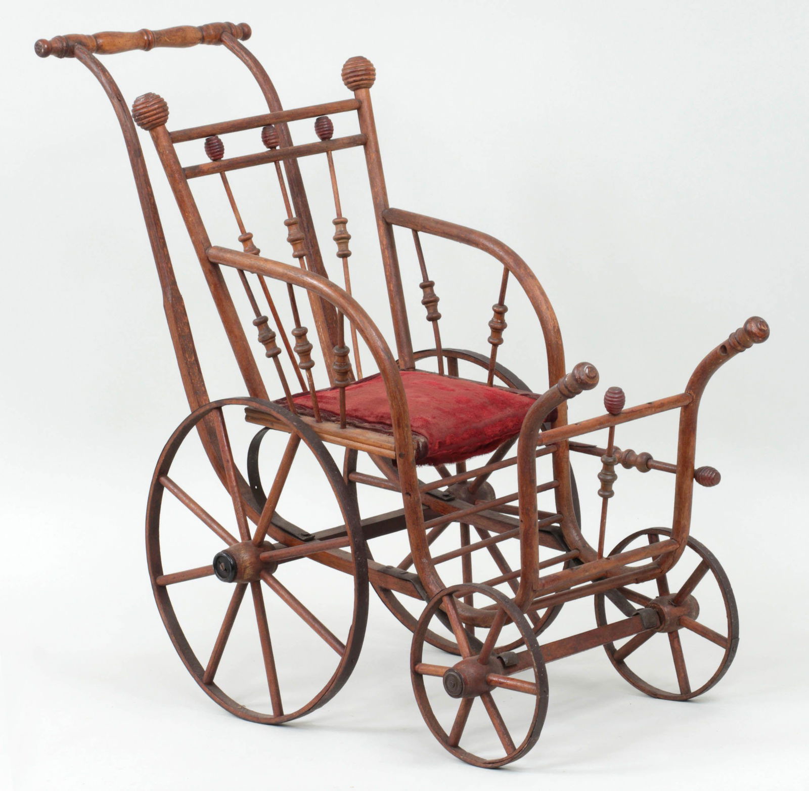 19th century stick and ball wooden doll stroller: 19th century stick and ball wooden doll stroller with wooden wheels and velvet seat cushion, circa 1895. Lacking some spindles, overall rickety, wear to velvet seat, and split to handle support. 24-1/