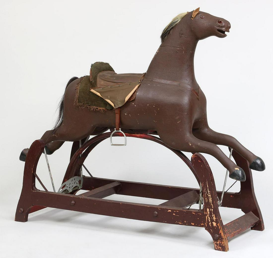 19th century Whitney Reed Corporation: 19th century Whitney Reed Corporation carved and painted wood rocking horse with saddle, stirrups, and base. Arched supports broken, horse well used. Horse excluding base 28-1/4''h, 48''w, 9-1/2''d.