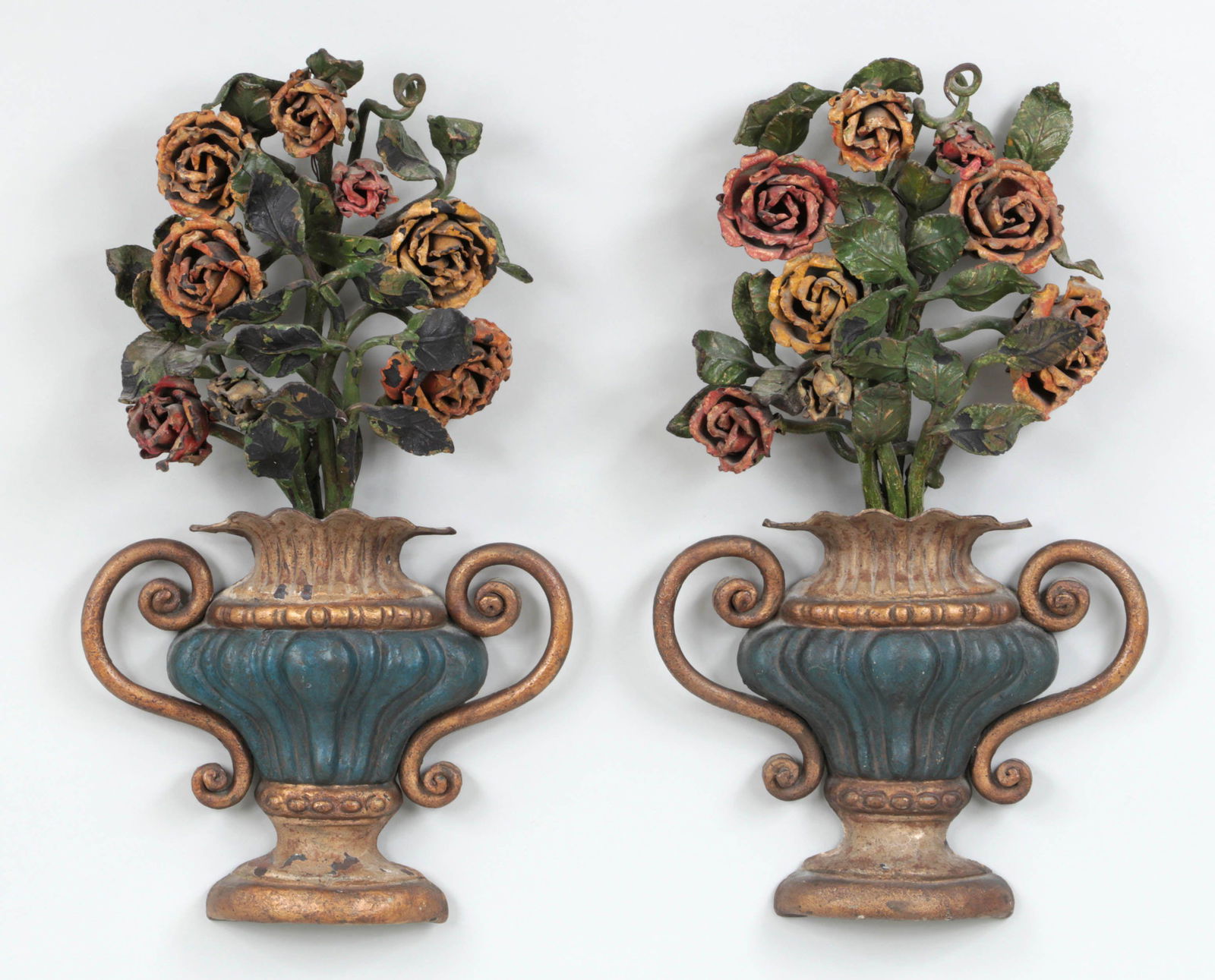 Pair of polychrome cast iron wall garnitures: Pair of polychrome painted cast iron wall garnitures of rose bouquets in footed urns. Paint loss. 20''h, 11-1/4''w, 5''d.