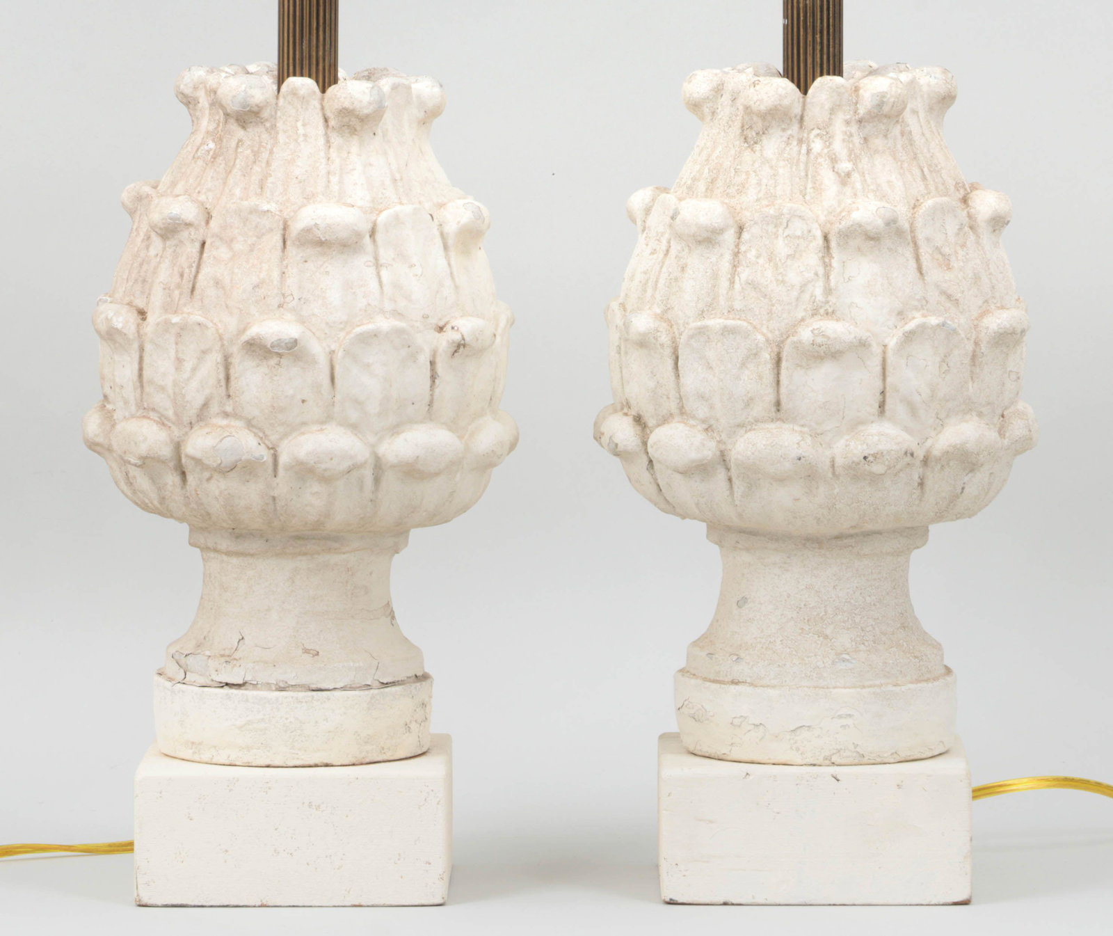 Pair of cast stone pineapple finials: Pair of whitewashed cast stone pineapple finials mounted as lamps. Wear to paint, losses. 14-1/2''h.