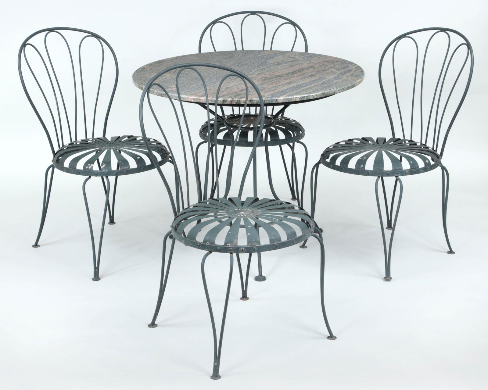 Five-piece wrought iron patio set: Five-piece wrought iron patio set, 20th century, to include: (4) spring seat chairs; and round granite top table. Table 29''h, 35-1/4''dia.