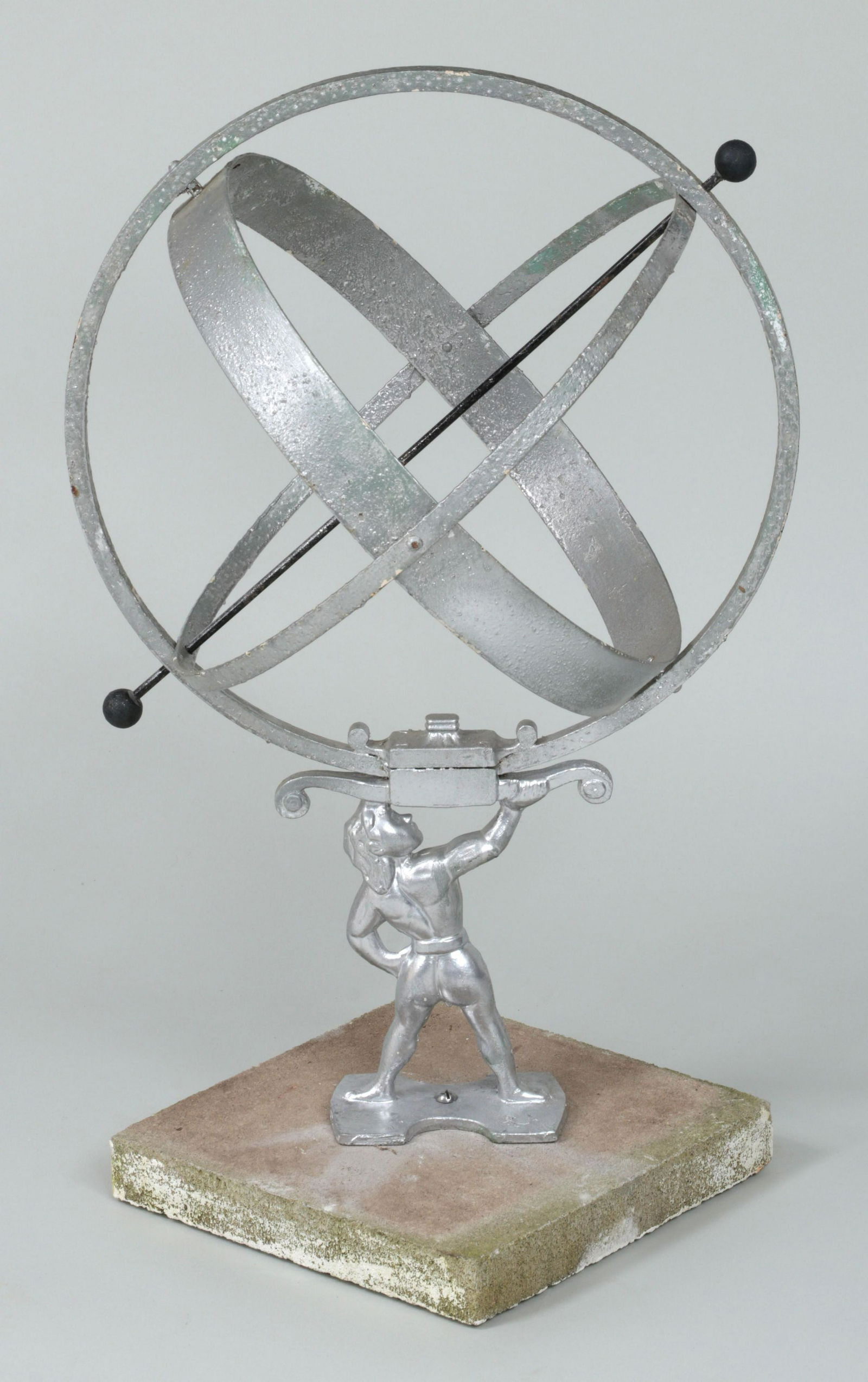 Wrought iron armillary: Wrought iron armillary with rod through center supported by figure of Atlas on cast stone base, painted silver. 23-3/4''h, 17-1/2''dia (excluding base).