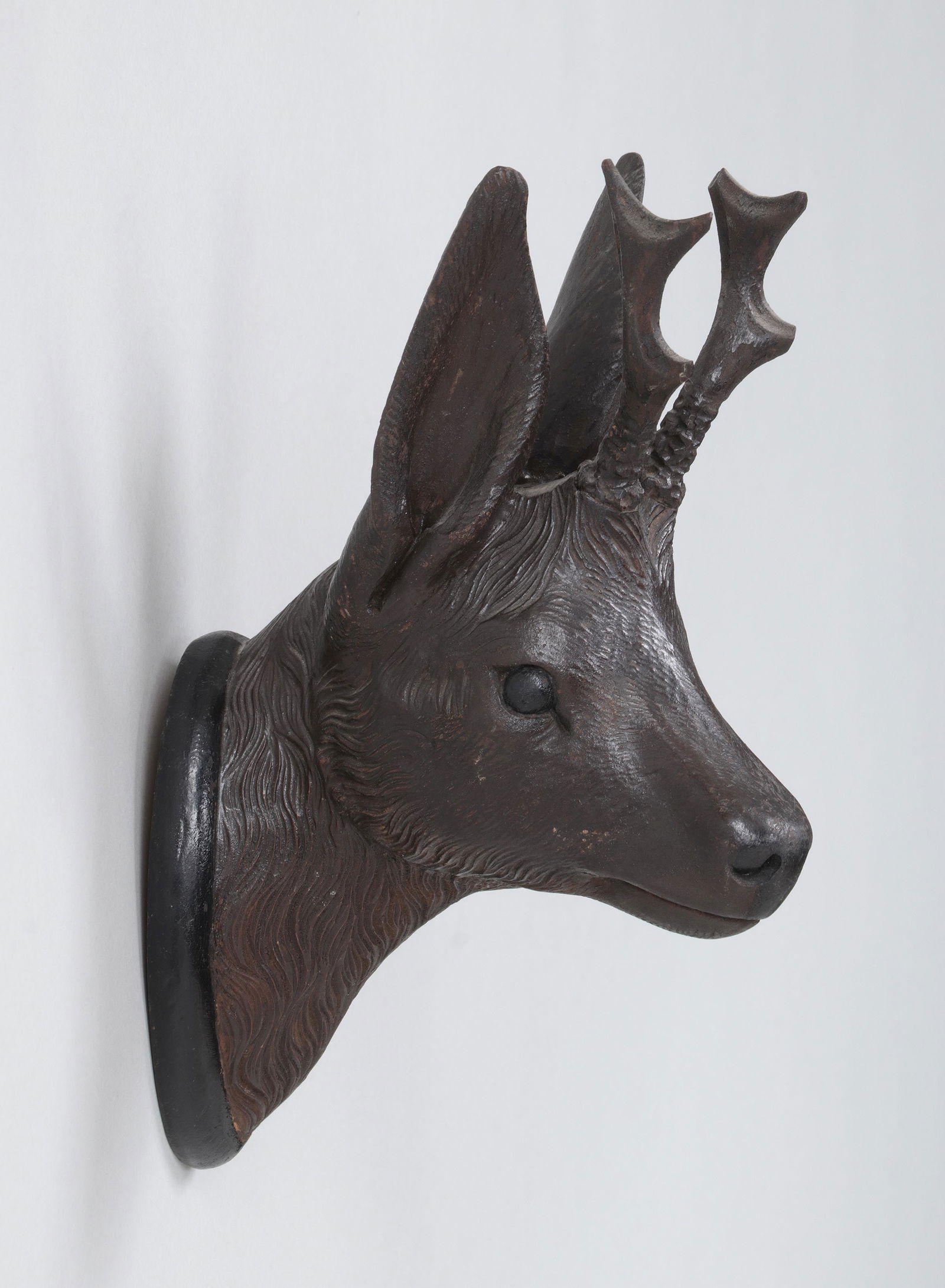 Black Forest carved wood deer head: Black Forest carved wood deer head mount. Minor splitting, minor losses near antlers, and wear to paint.10-3/4''h, 3-5/8''w, 6''d.