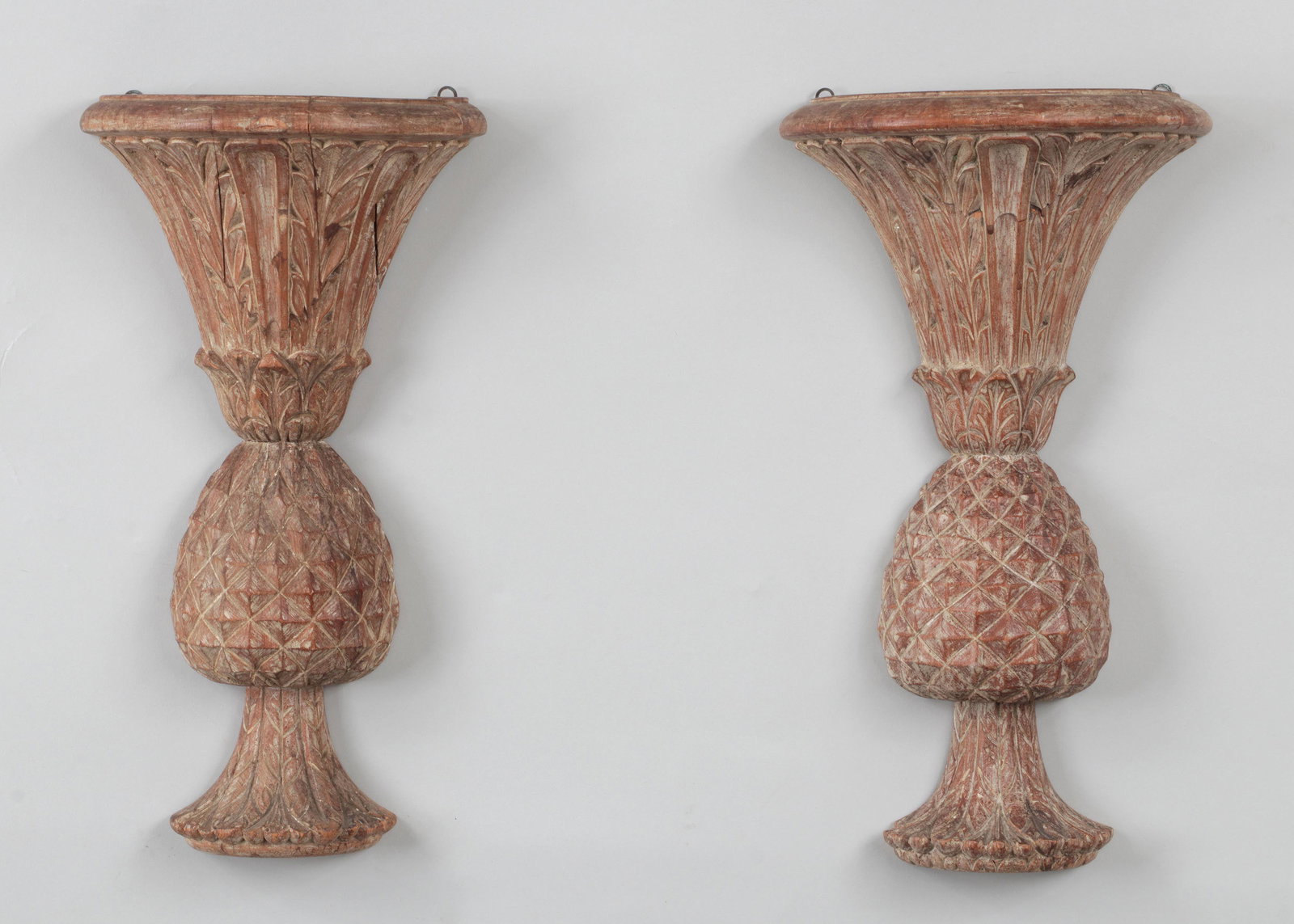 Pair of carved wood pineapple wall pockets: Pair of carved wood pineapple wall pockets. Loss to base of one, repairs, and cracks. 15-1/2''h, 8-5/8''w, 4''d.