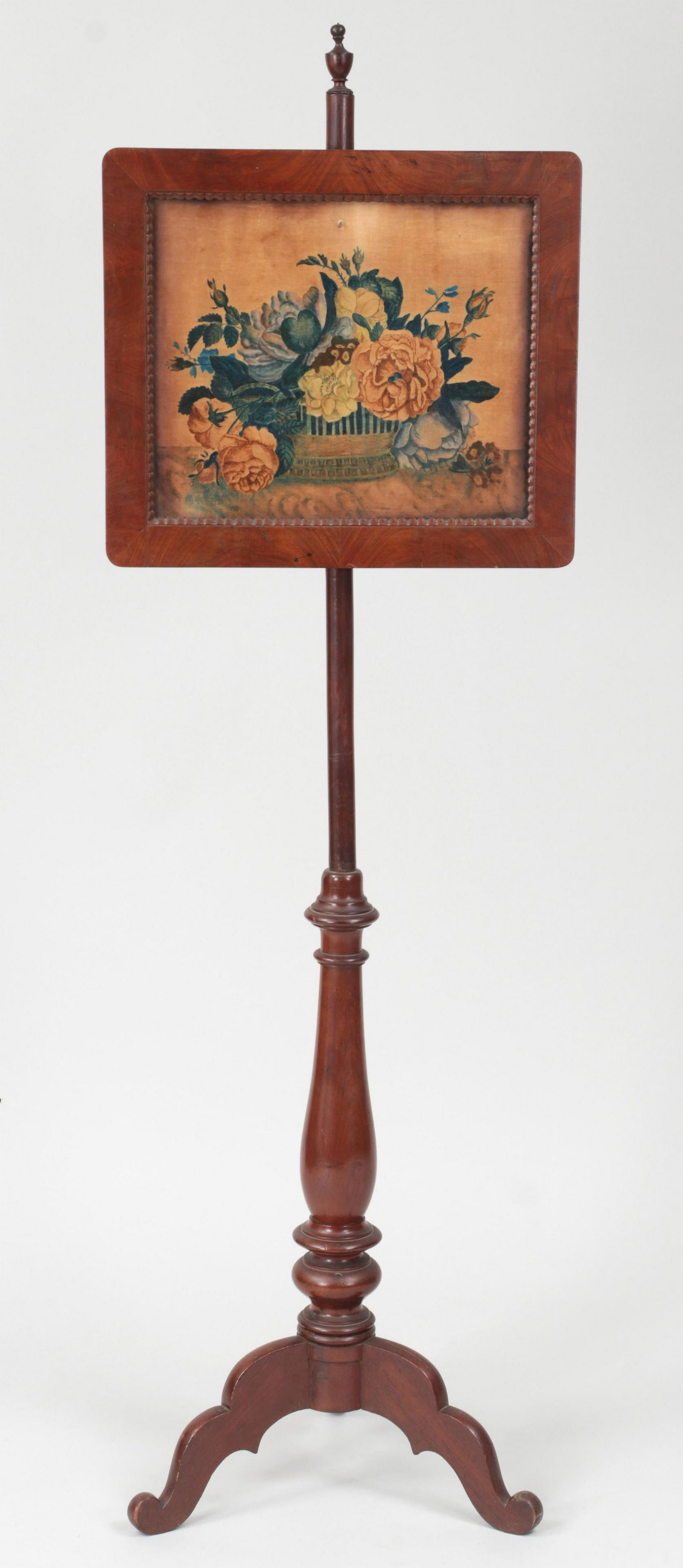 19th century American mahogany pole screen: 19th century American mahogany pole screen with felt theorem painting depicting basket of roses. Repairs, split to base, theorem toned and with small puncture at center. 58-3/4''h.