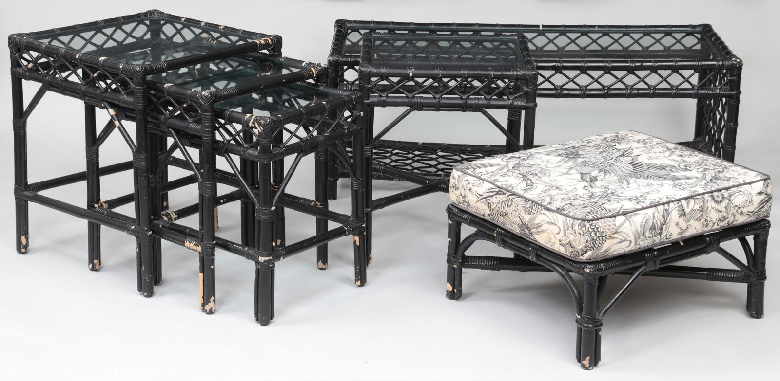 Six-piece bamboo set: Six-piece bamboo set, painted black, to include: rectangular glass top coffee table; three glass top nesting tables; ottoman with cushion; and small square glass top side table. Paint loss and some mi