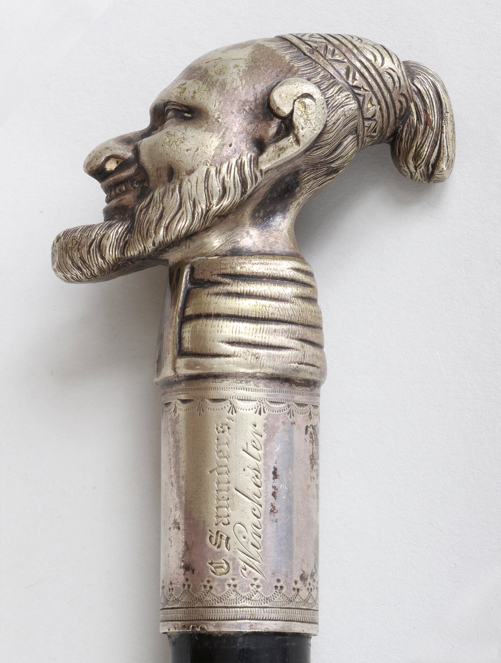 'C. Saunders, Winchester'' cane: Cane with silver-plated handle depicting bearded man, inscribed ''C. Saunders, Winchester'', having ebony wood shaft and brass ferrule. Wear to silvering. 37-3/4''h. Provenance: Estate of William Kran