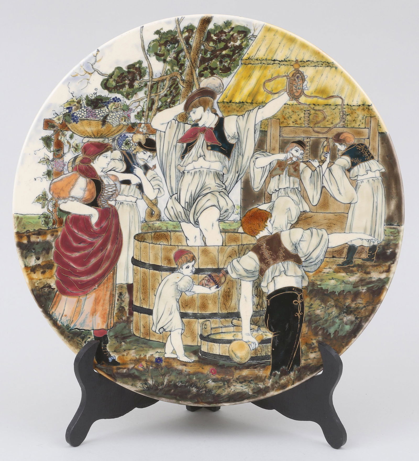 Zsolnay charger: Zsolnay charger with folkloric Hungarian wine-making scene, glazed with hand-painted, enamel and gilt decoration, late 19th century, possibly by Armin Klein, with five tower mark. Crazing, small glaze