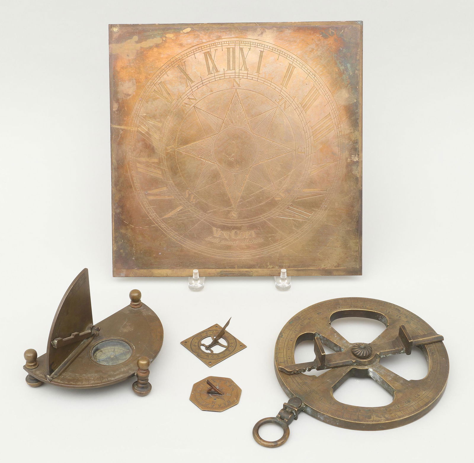 Group of (5) brass instruments: Group of (5) brass instruments, to include: large square sundial face by Van Cort Instruments; equinoctial sundial compass; hanging verniered instrument with two sighting holes, marked ''L.C. Eichner'