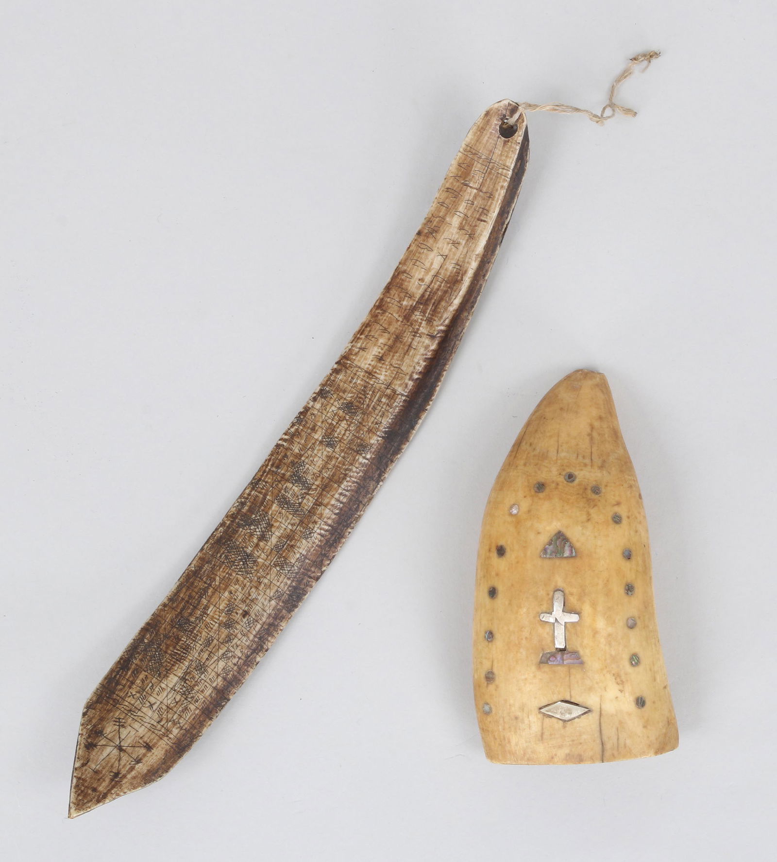 Group of (2) Marine Art items: Group of (2) Marine Art items, to include: sailor-made silver and abalone inlaid whale tooth with central cross motif; and scrimshaw bone implement, possibly Eskimo, having pointed tip and designs to