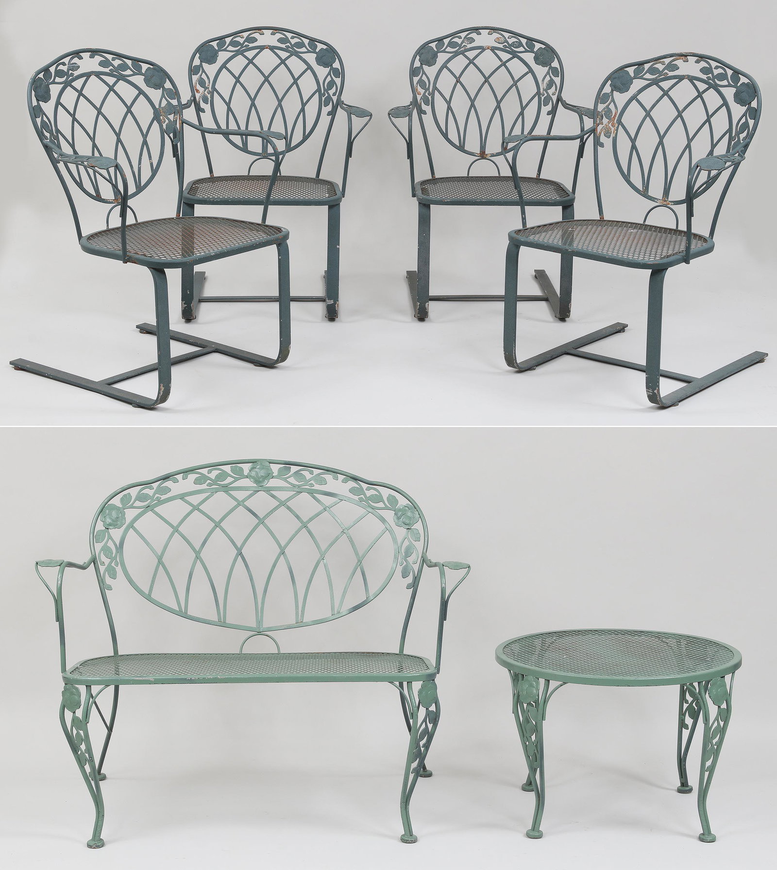 Five piece wrought iron patio set: Five piece wrought iron patio set in rose pattern, to include: (4) rocking armchairs with screen seats; settee with screen seats; and small round table with screen top. Wear from use, Settee and table