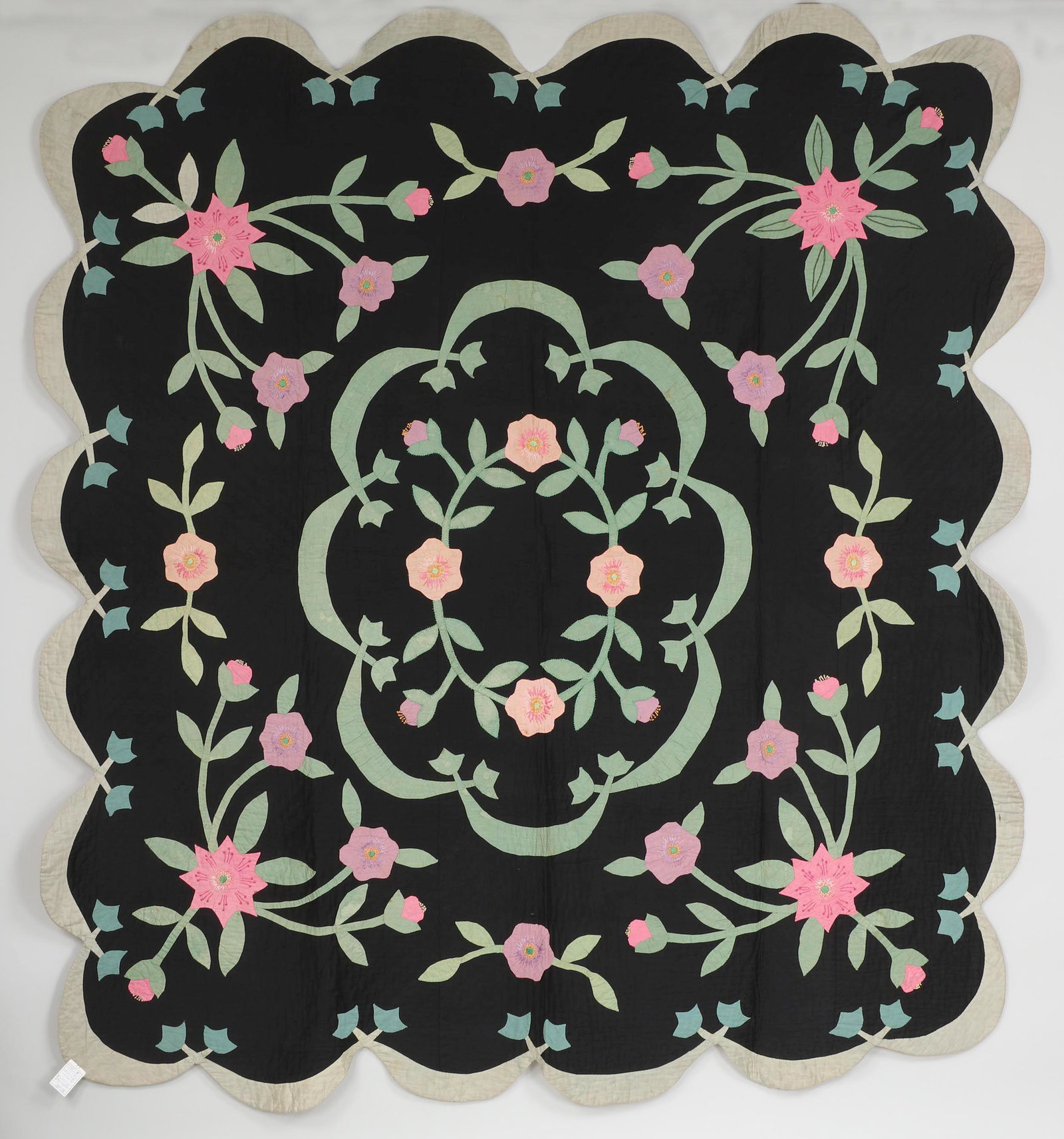 Floral applique quilt: Floral applique quilt on black ground with scalloped border, circa 1920s-1930s, cotton. Some stains, fading. 89''h, 82''w. Provenance: Estate of Laura Fisher, New York, NY. Catalog note: ''This is a r