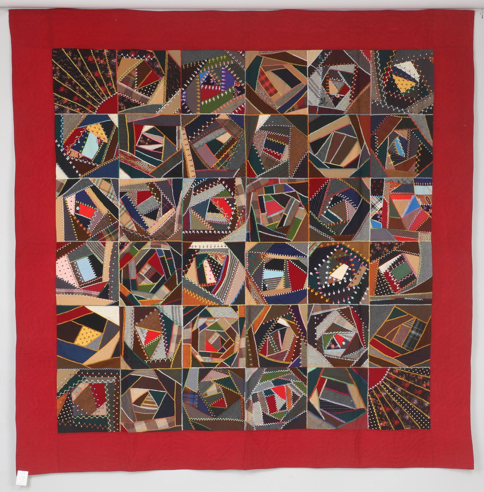 Organized Crazy Sampler quilt: Organized Crazy Sampler quilt with wide wine border, various embroidered stitches used, late 19th century. Some stains to back. 81''h, 81''w. Provenance: Estate of Laura Fisher, New York, NY.