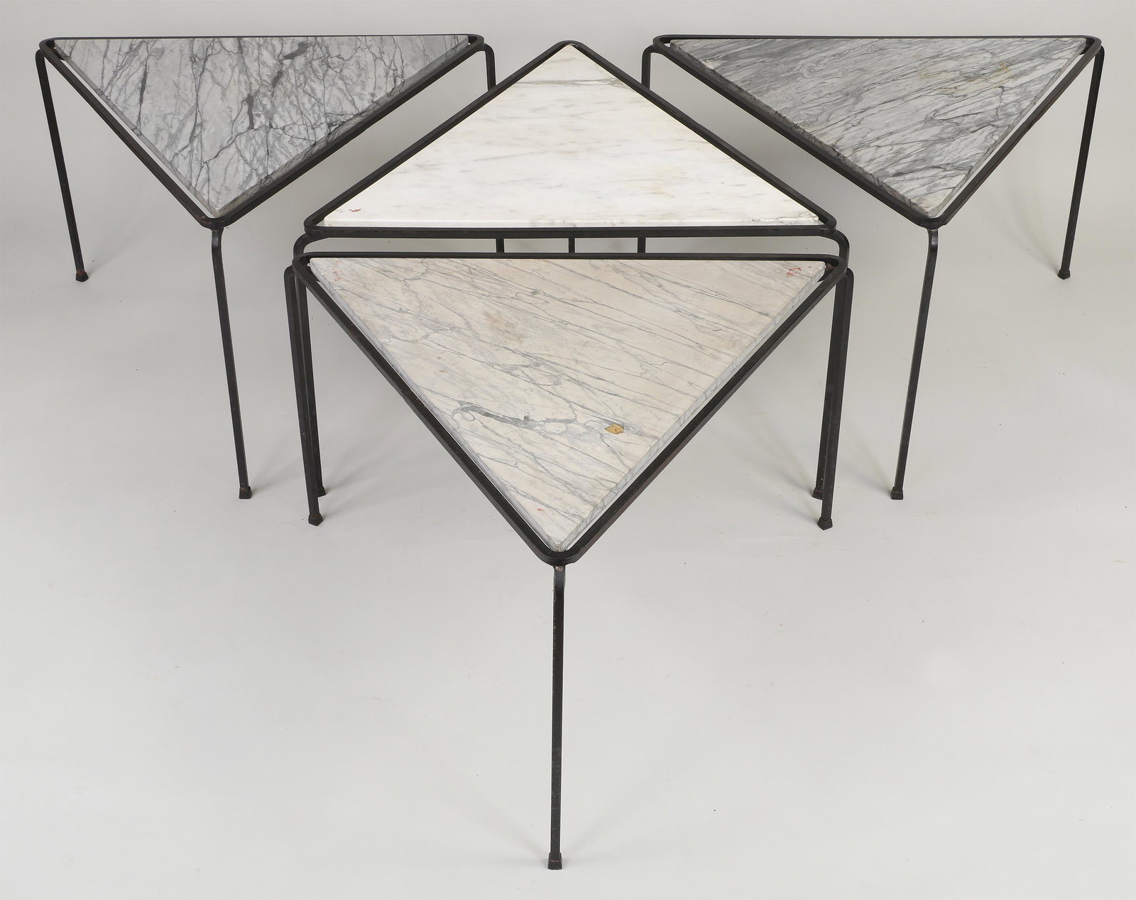 Mid-century marble-top triangular tables: Set of (4) Mid-century marble-top wrought iron triangular side tables. Missing bumpers, a few rough edges and scratches to marble. 20-1/2''h, 33-3/4''w, 29-1/4''d.