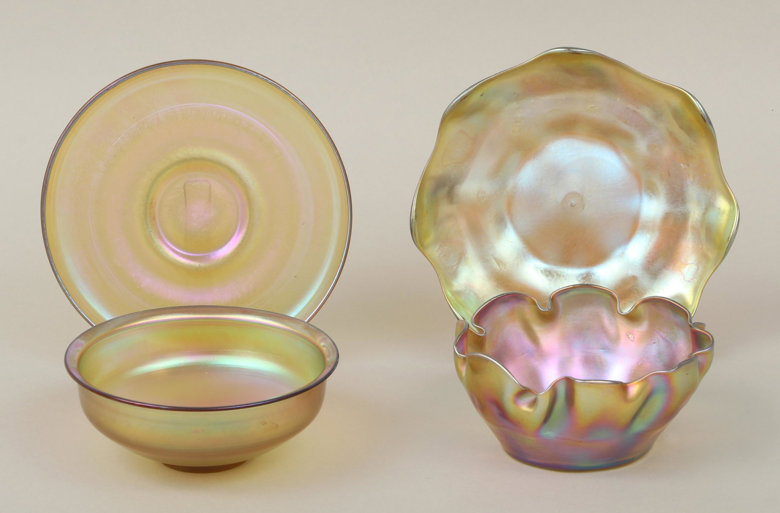 Group of (2) Tiffany Studios favrile glass bowls: Group of (2) Tiffany Studios favrile glass bowls with underplates, one having crimped rim and scalloped underplate, each piece signed ''L.C.T.'' to bottom. Minor surface wear from use, two small fleab