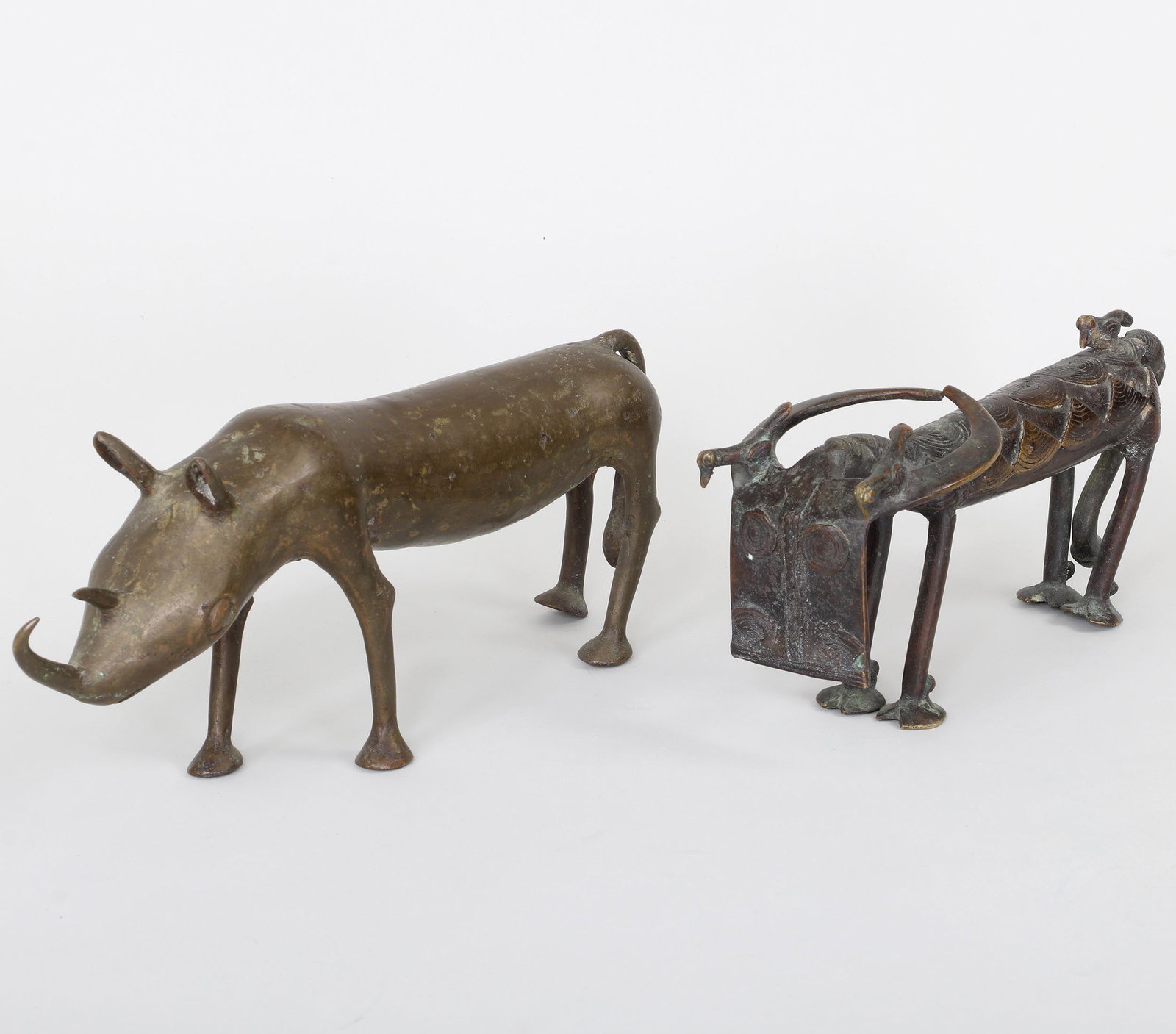 Group of (2) African bronze sculptures: Group of (2) African bronze sculptures, to include: Water buffalo with birds perched on its horns and back; and rhinoceros. Wear from use, casting imperfections. Rhino 5-5/8''h, 13-3/4''l, 2-5/8''w. P