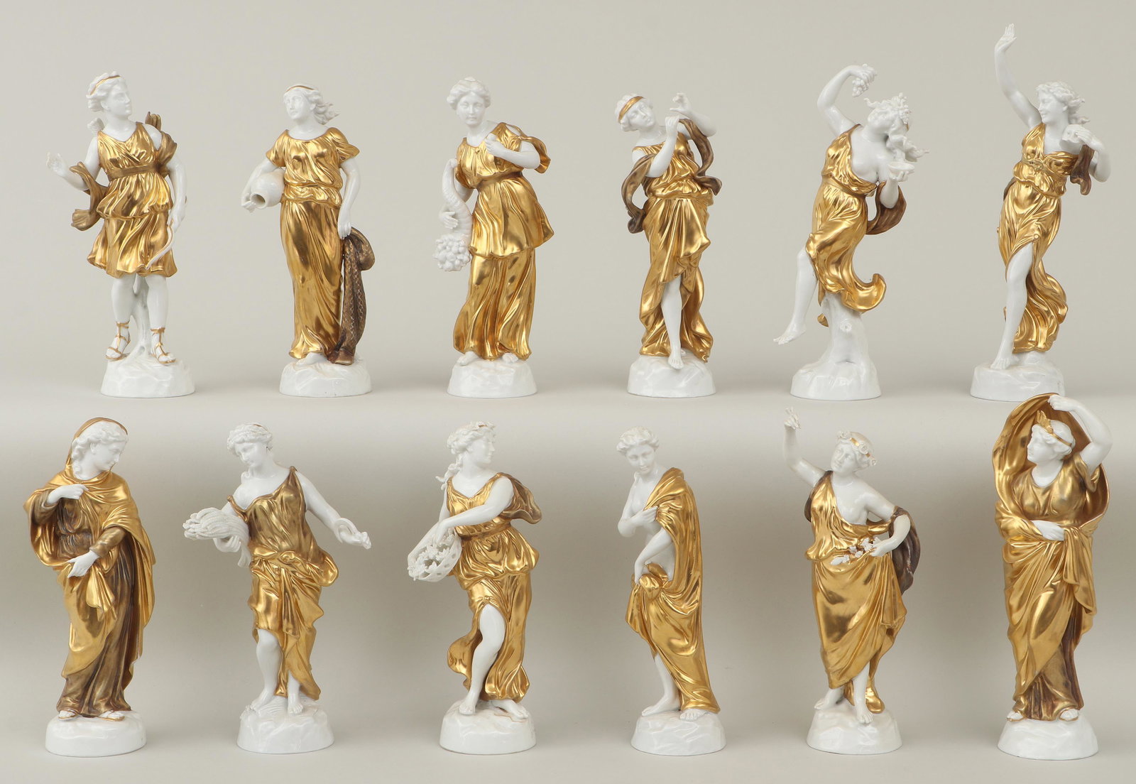 Set of (12) Capodimonte porcelain figures: Set of (12) Capodimonte gilt porcelain figures of classical women, representing the twelve months of the year, marked with ''N'' and crown to bottom. One missing flute, minor losses to flower petals a