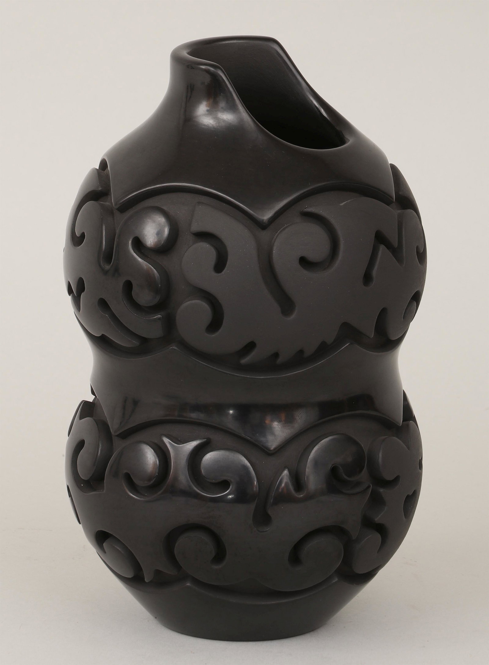 NATHAN YOUNGBLOOD (Santa Clara Pueblo, b. 1954): NATHAN YOUNGBLOOD (Santa Clara Pueblo, b. 1954), Santa Clara carved blackware pitcher, of double gourd form, with alternating matte and glaze finishes, signature and cipher incised to bottom. Light we