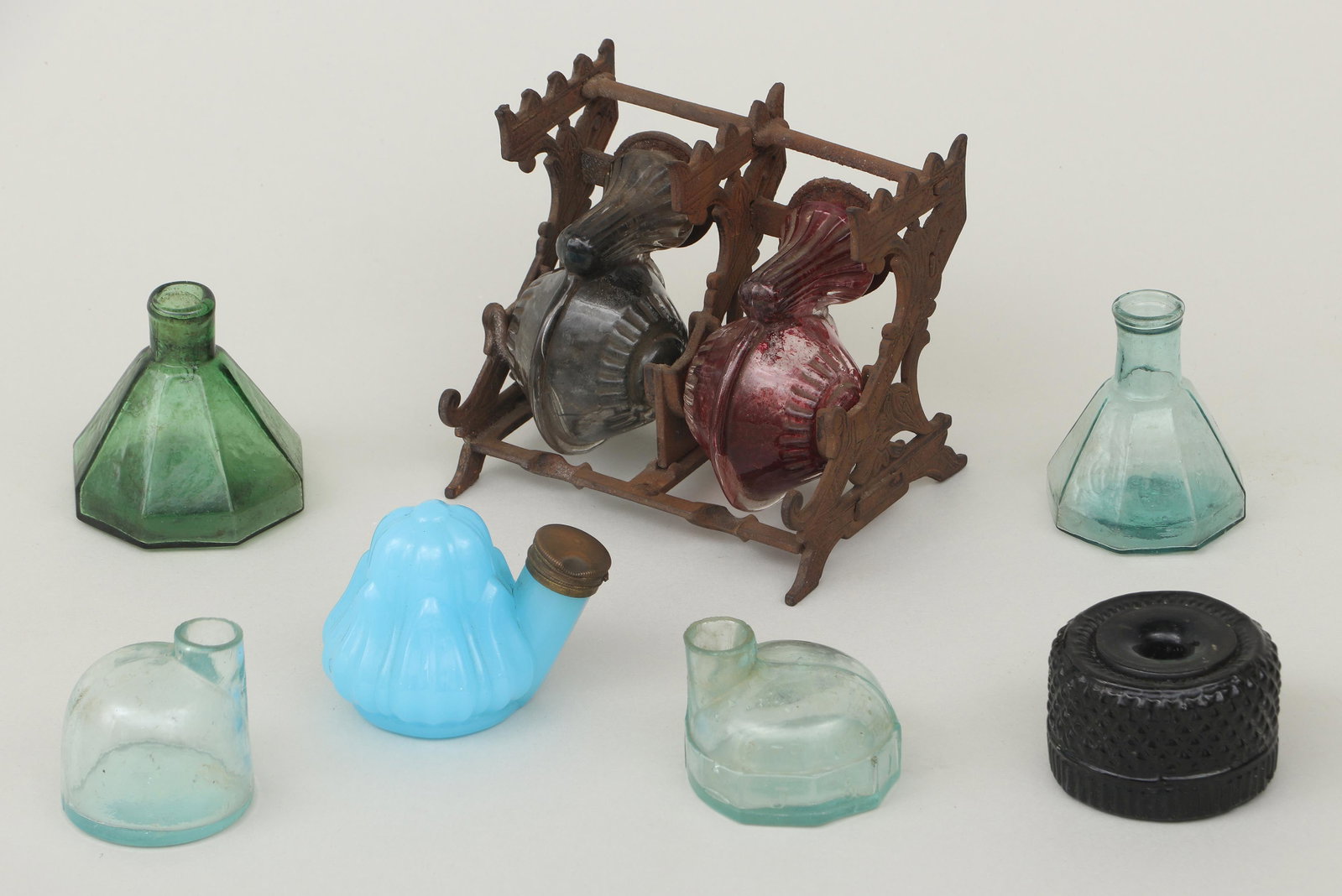 Group of (7) mold-blown glass inkwells: Group of (7) mold-blown glass inkwells, to include: double inkwell with snail-form wells, marked ''PAT. JAN 14 .79'' to backs of well covers, (stand oxidized); early 19th century amber three mold-blow