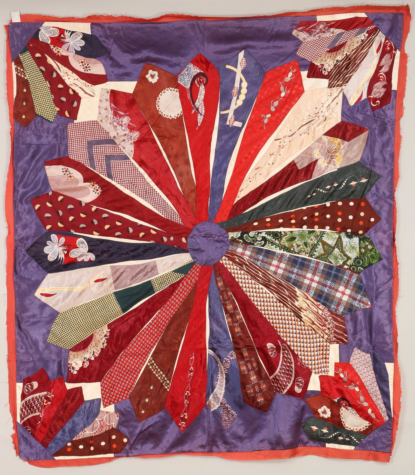 'Circle of Ties'' quilt top: ''Circle of Ties'' quilt top with blue circle center and red border, circa 1940s, rayon. Fraying to border and stains on back. 80''h, 70''w. Provenance: Estate of Laura Fisher, New York, NY.