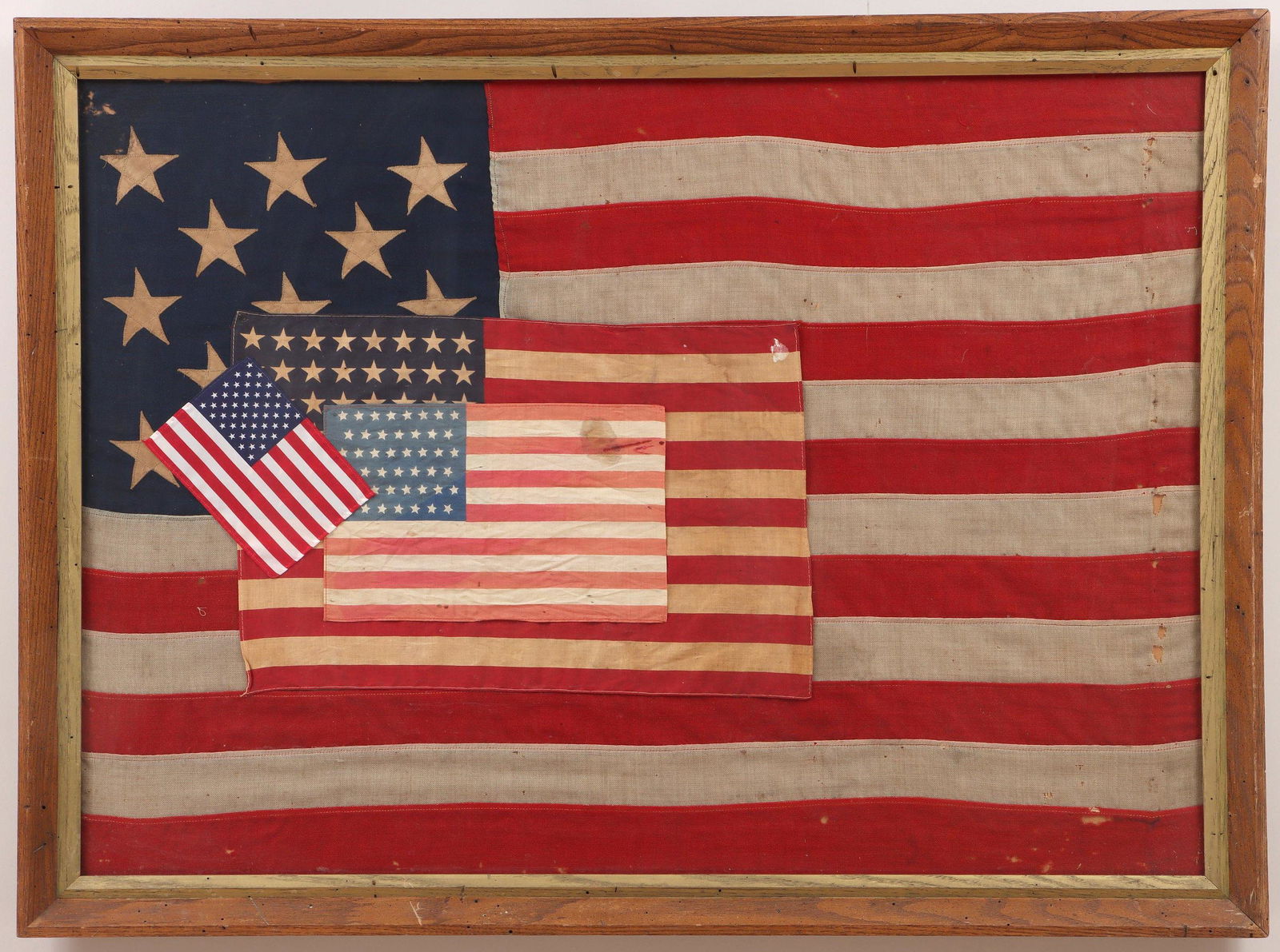 13-star American flag, 19C/20C.: 13-star American flag, late 19th/early 20th century, with hand-stitched linen stars in a 3-2-3-2-3 pattern, wool bunting canton and stripes, and canvas hoist with brass grommets, (toning, holes). Fram
