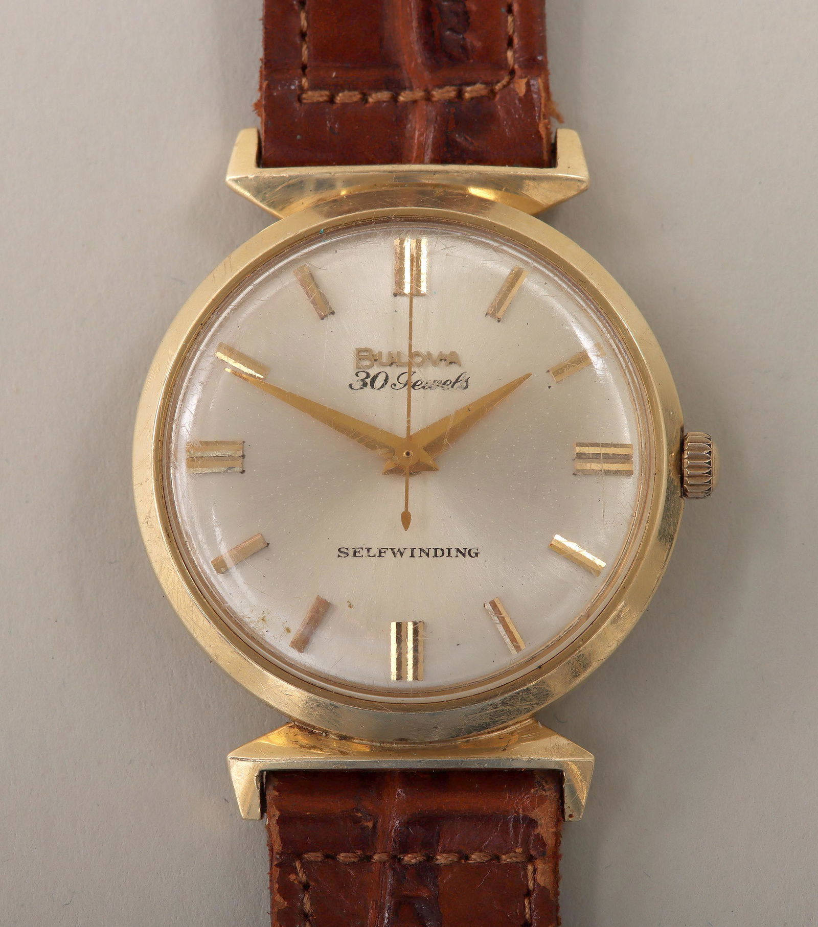 Bulova 14k gold: Bulova 14k gold self-winding men's wristwatch, 30 jewels, with leather band, marked and numbered on movement and back. Band with wear from use. 9-1/8''l (open); 1-5/16''dia, face 1-1/8''dia; approxima