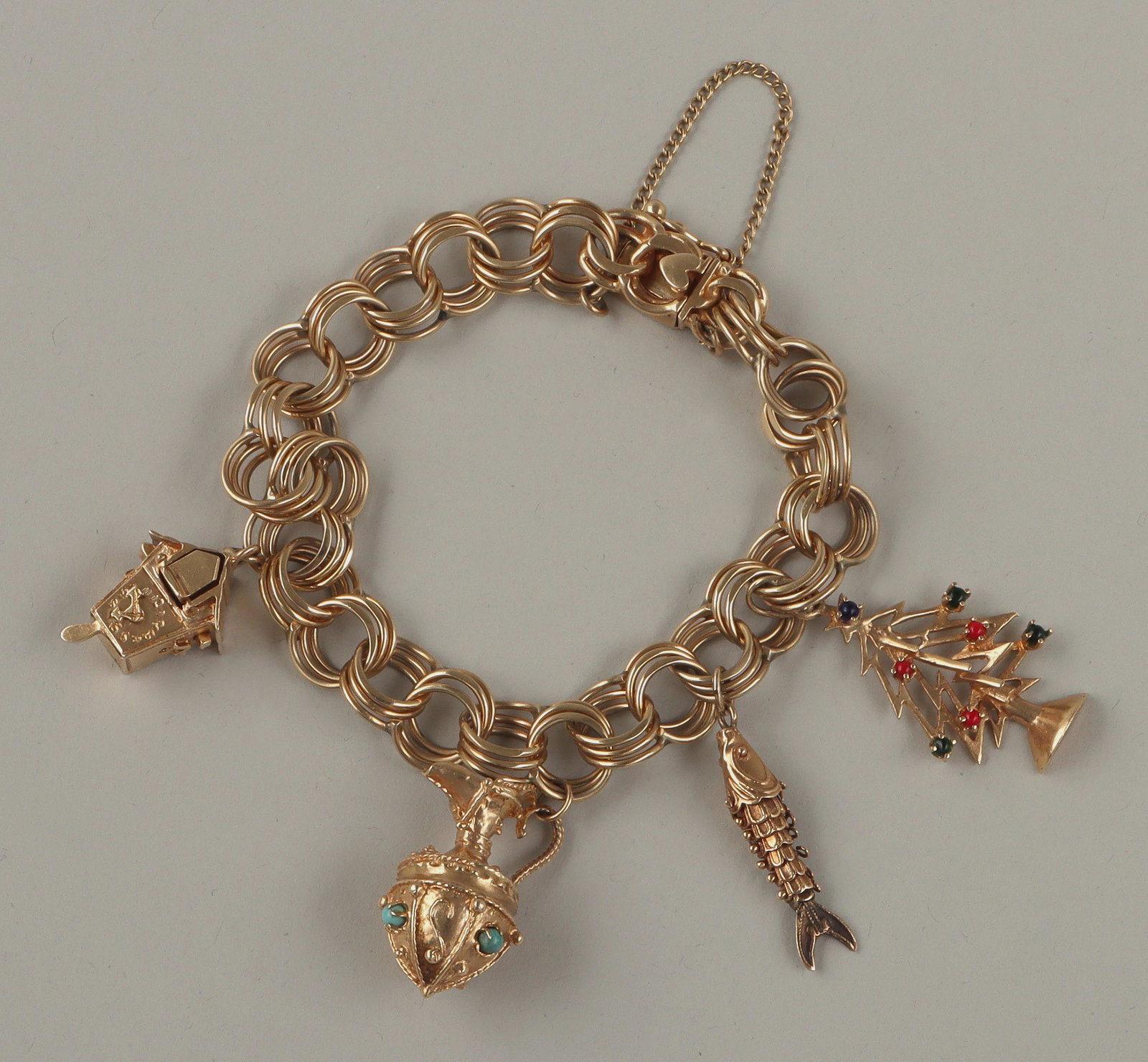 14k gold charm bracelet: 14k gold charm bracelet, having three-layer parallel chain with (4) charms, charms to include: cuckoo clock, with pop-out mechanism that reveals a painted bird, maker's marks to back, (paint losses); 