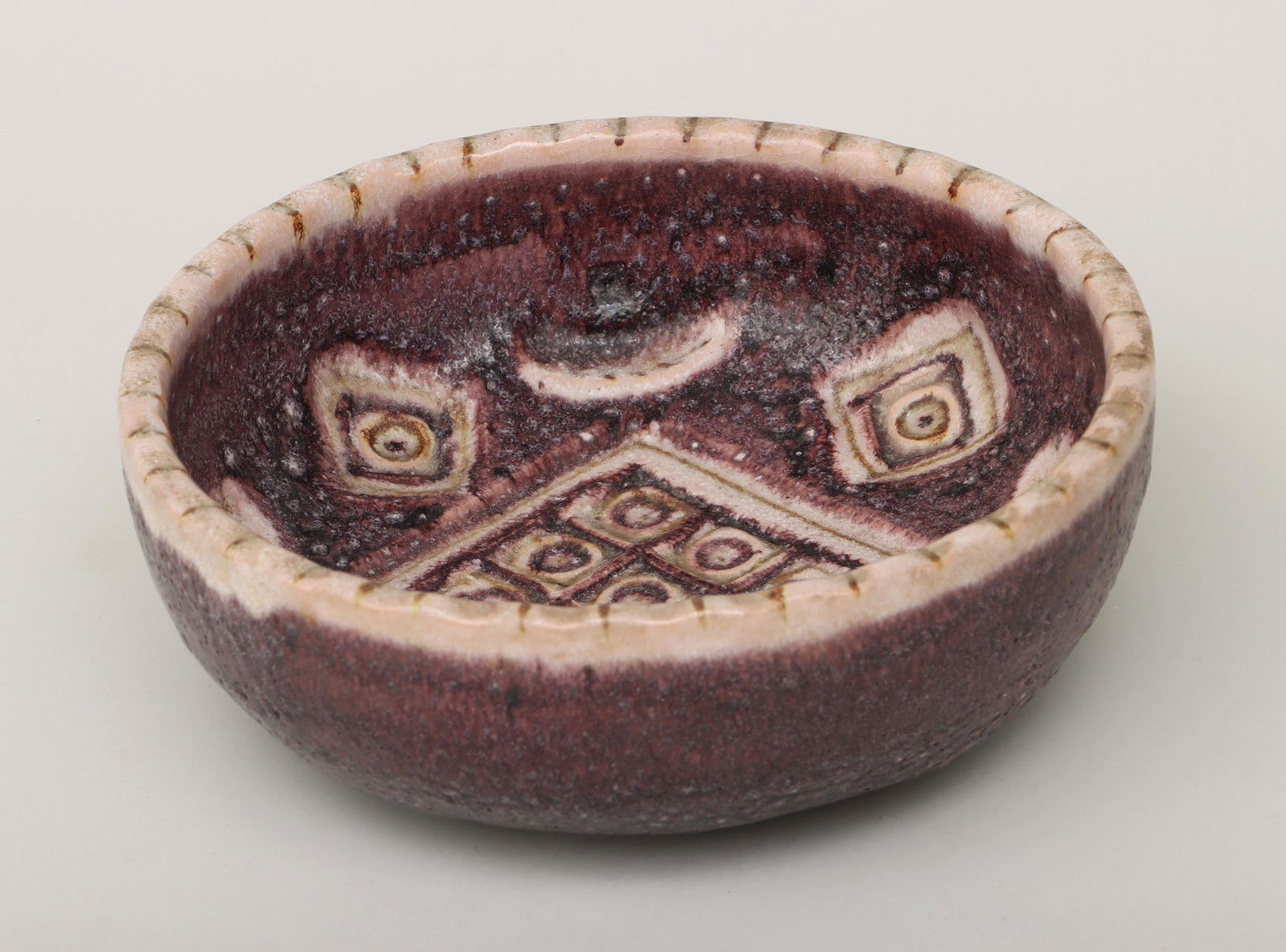 GUIDO GAMBONE: GUIDO GAMBONE (Italian, 1909-1969), bowl with relief-carved geometric decoration, glazed earthenware, inscribed ''Italy'' and with donkey mark to underside. Some crazing, minor wear from use. 3-1/4''h
