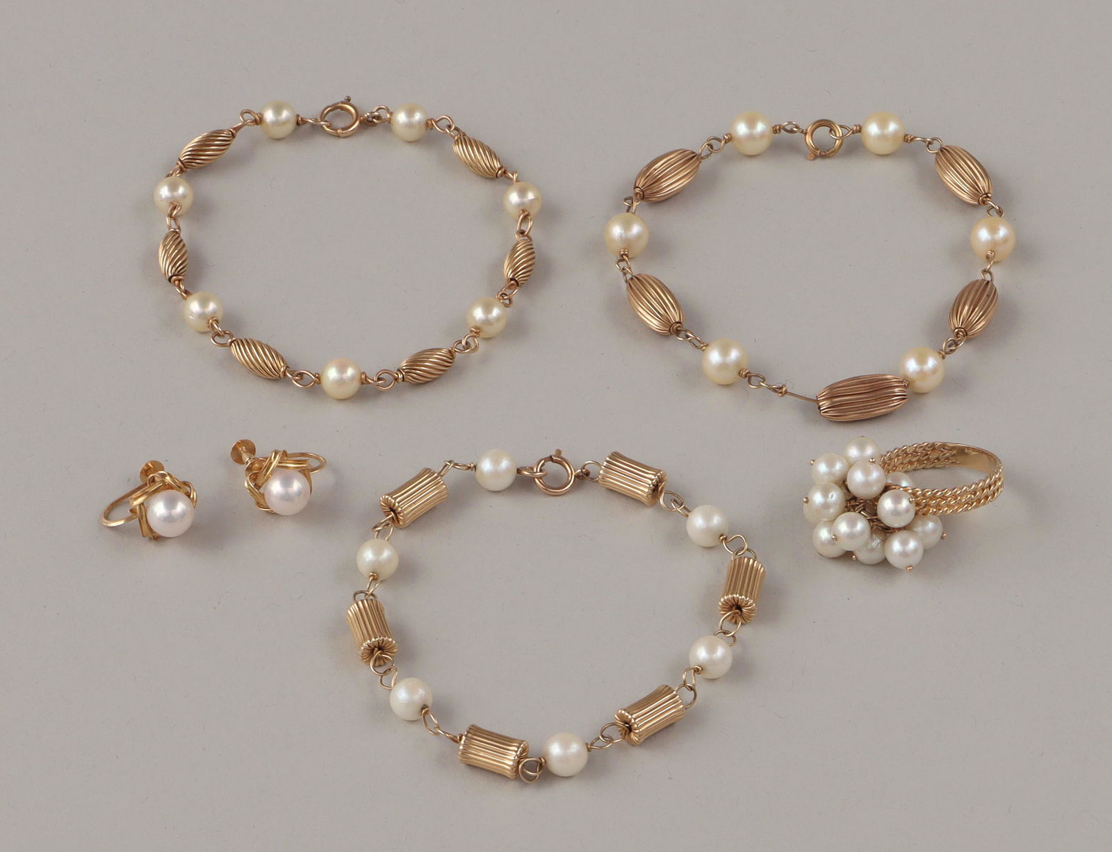 Pearl and gold jewelry: Group of (5) pearl and gold jewelry, to include: pair of 18k screw-back earrings, each with a pearl in an interwoven gold setting, marked on backs; 14k pearl cluster ring, numbered inside band, (band