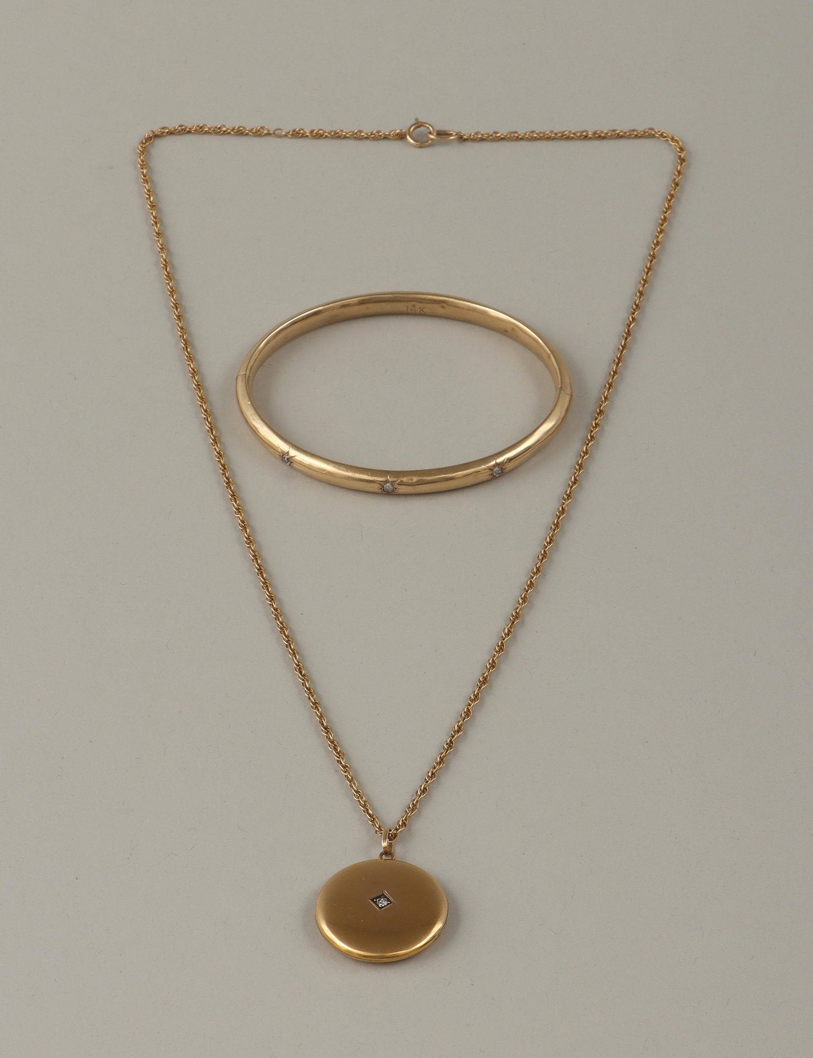 Group of (2) diamond 14k jewelry: Group of (2) diamond and 14k gold jewelry, to include: locket necklace, having round locket with (1) diamond on the front and leaves inside, locket marked inside and on loop, with rope chain, marked t