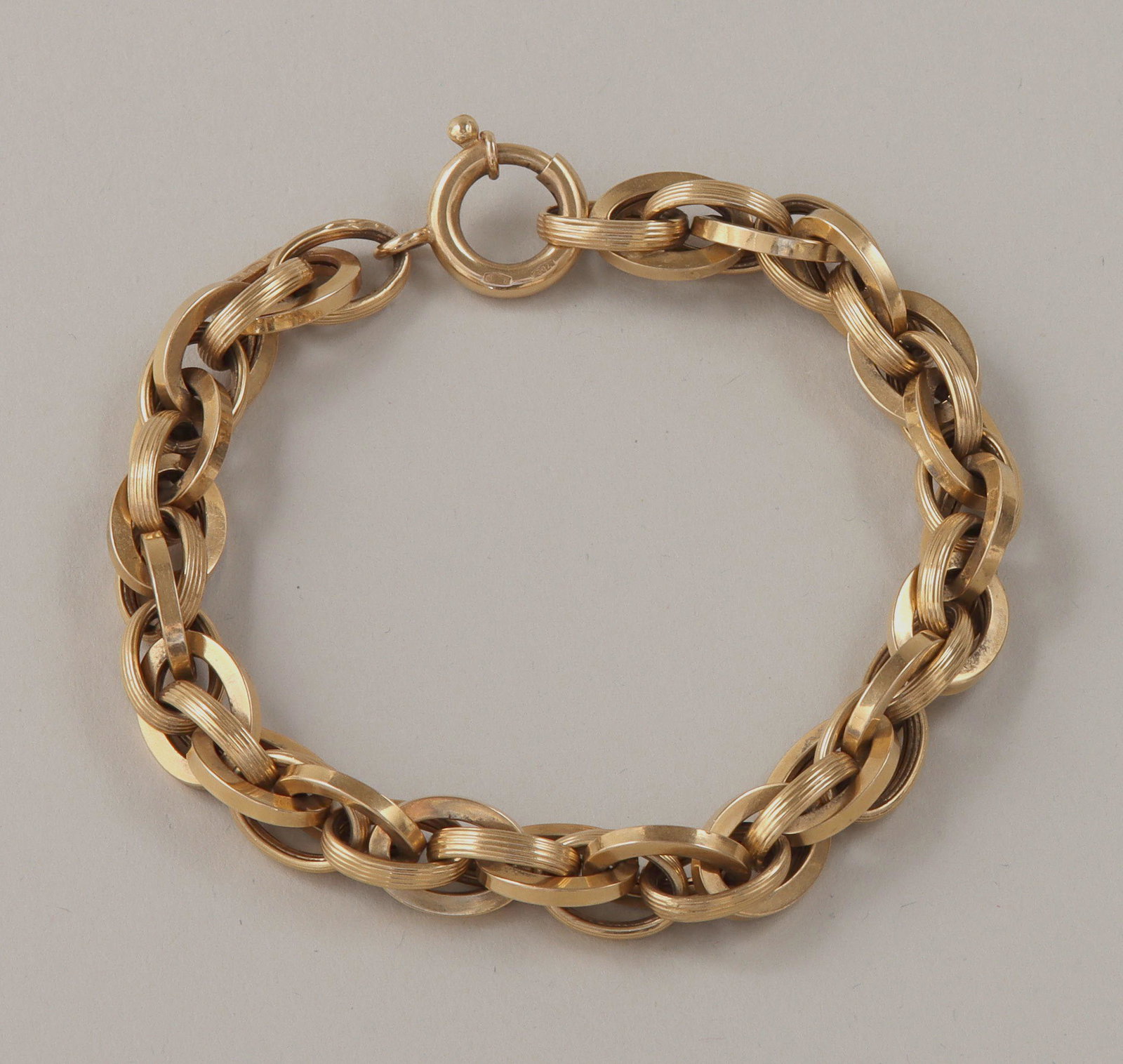Unoaerre 18k bracelet: Unoaerre 18k gold rope chain bracelet, having applied gold rectangle with purity and maker's marks at one end of chain, purity marks stamped to clasp. 8-1/4''l (open); approximate weight 8.8 dwt.