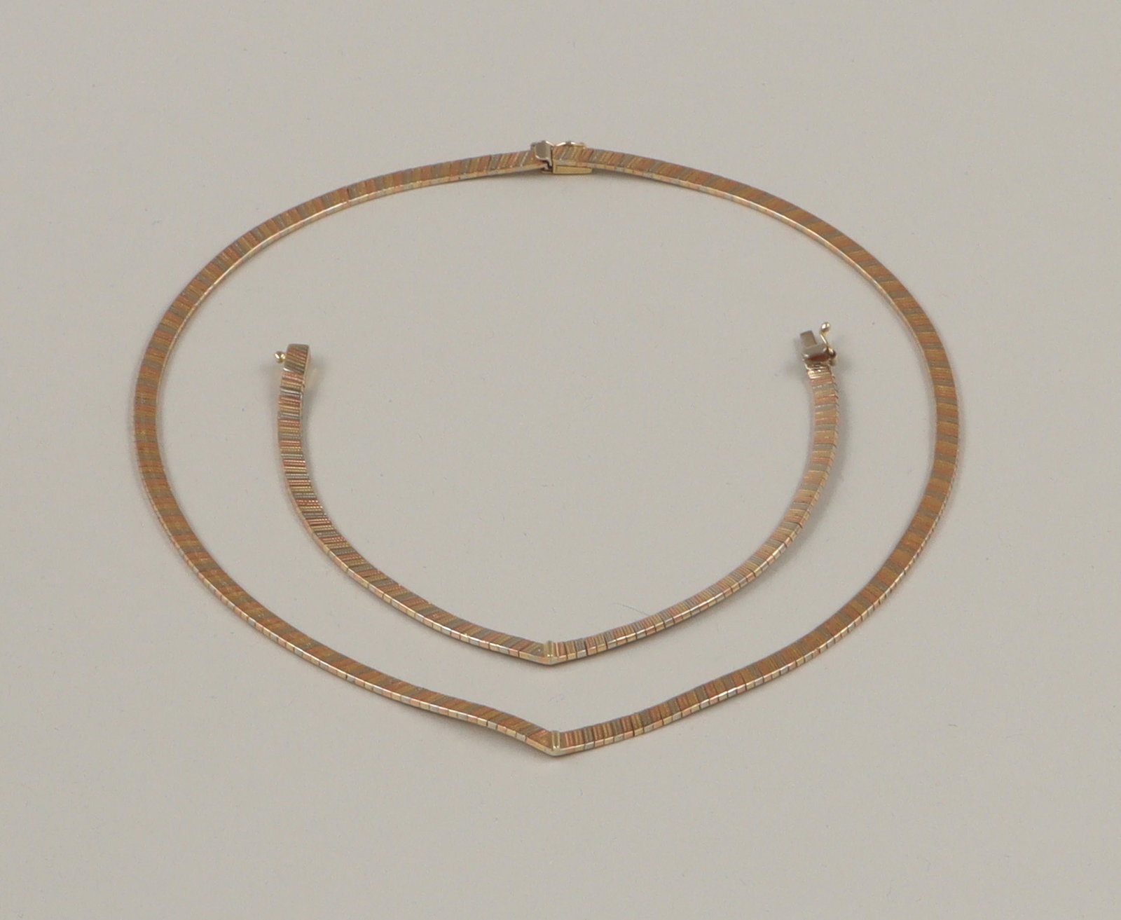 Two-piece set of 14k chevron jewelry: Two-piece set of 14k white, yellow and rose gold chevron jewelry, having omega chains with alternating white, yellow and rose gold links and yellow gold bar applied at center point, to include: neckla