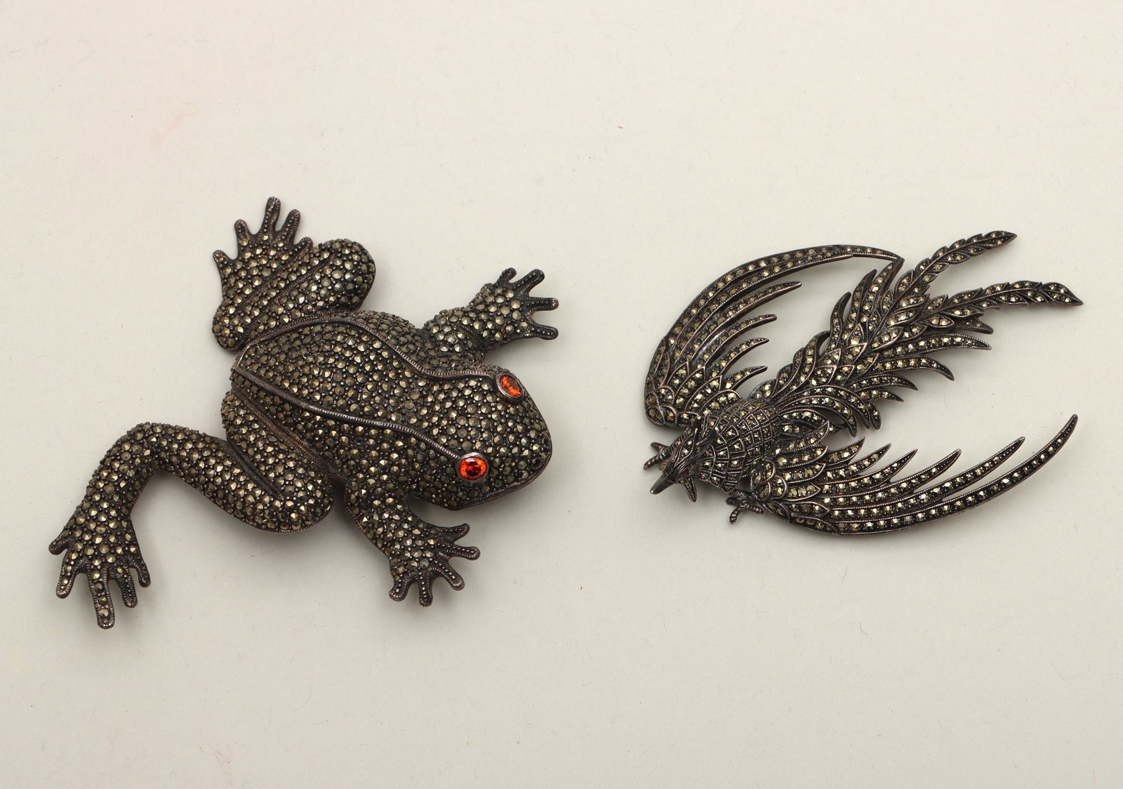 Group of (2) large sterling brooches: Group of (2) large sterling silver brooches, having pave bodies with round-cut precious and semi-precious stone eyes, to include: ho ho bird, with (2) rubies for eyes, marked to back; and frog, with (