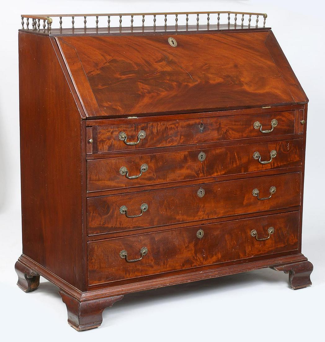 American mahogany slant front desk: American mahogany slant front desk with brass galleried top, drop front and fitted interior, over four graduated drawers, set on ogee bracket base. Repairs, wear from use. 44''h (including gallery), 4