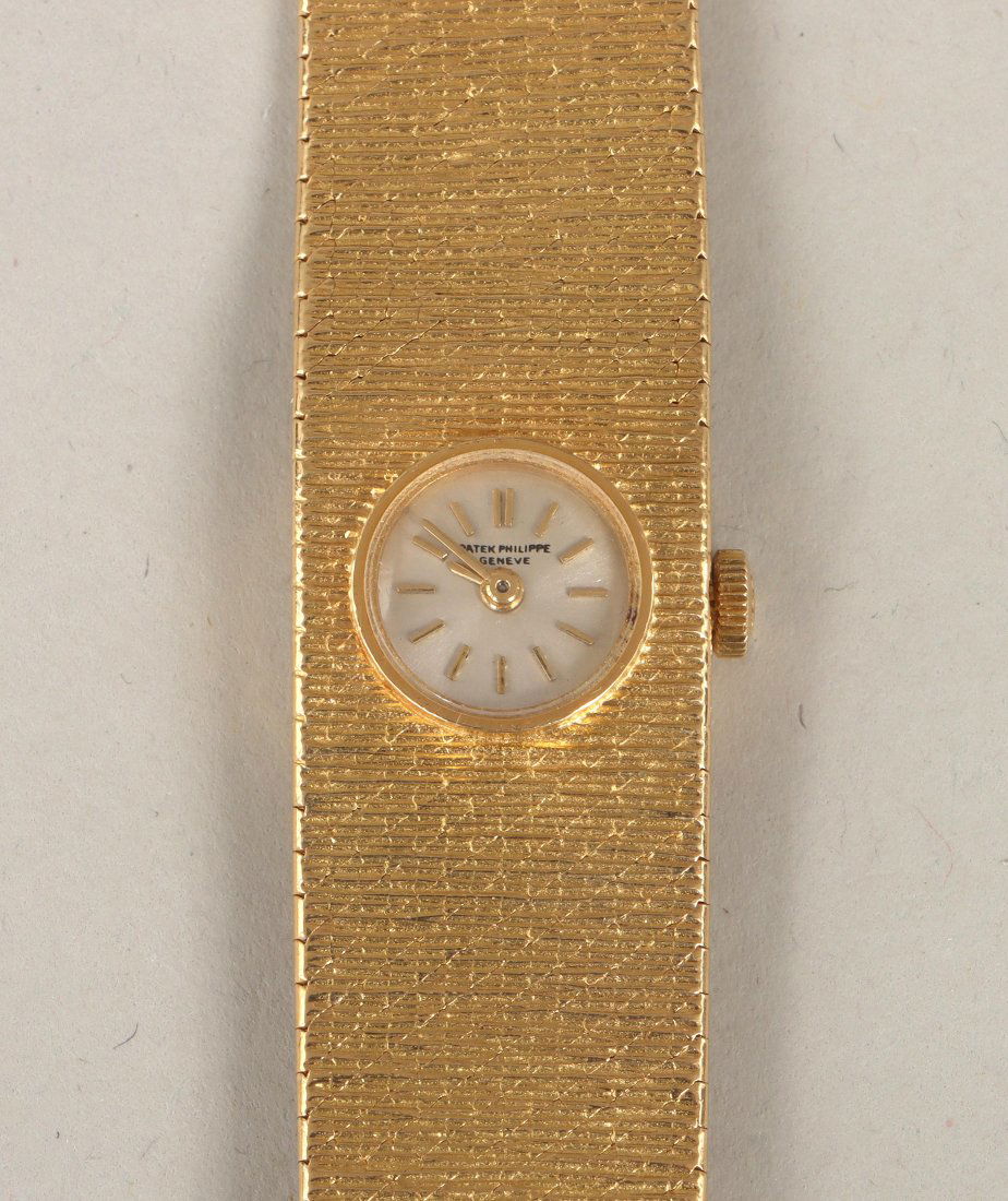 Patek Philippe 18k wristwatch: Patek Philippe 18k gold women's wristwatch, 20 jewels, movement no. 990870, with 18k gold mesh band. 6-3/16"l; face 7/16"dia; total approximate weight 31.3 dwt. Provenance: Acquired by current owner f