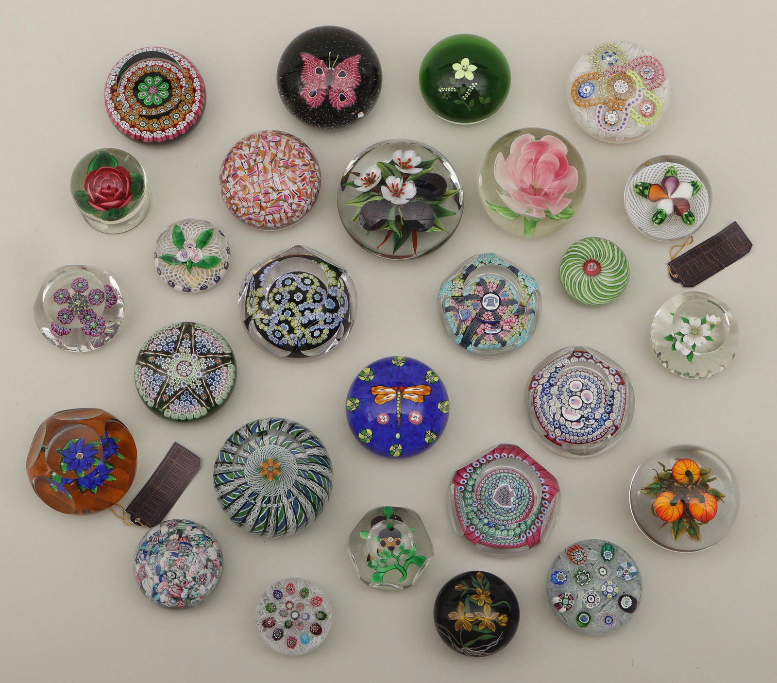 Group of (27) glass paperweights: Group of (27) glass paperweights, to include: plums by Rick Ayotte; yellow flowers on green ground by Paul Stankard; yellow flowers on black ground by Mayauel Ward; pumpkins by Ken Rosenfeld; vegetabl