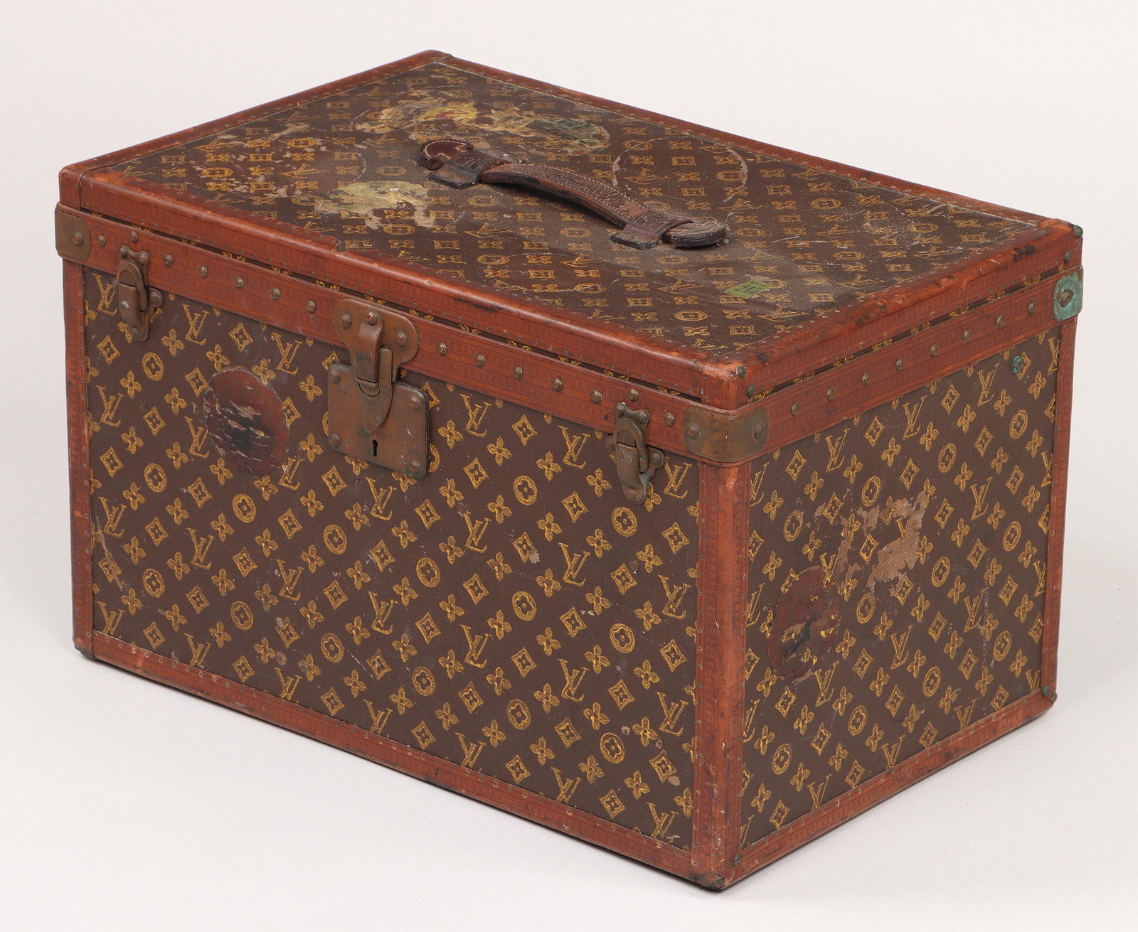 Louis Vuitton monogram travel case: Louis Vuitton monogram travel case, canvas-covered hard case having brass locks and leather top handle, early 20th century. Shows wear from use with scuffs, scratches and surface loss; losses to leath