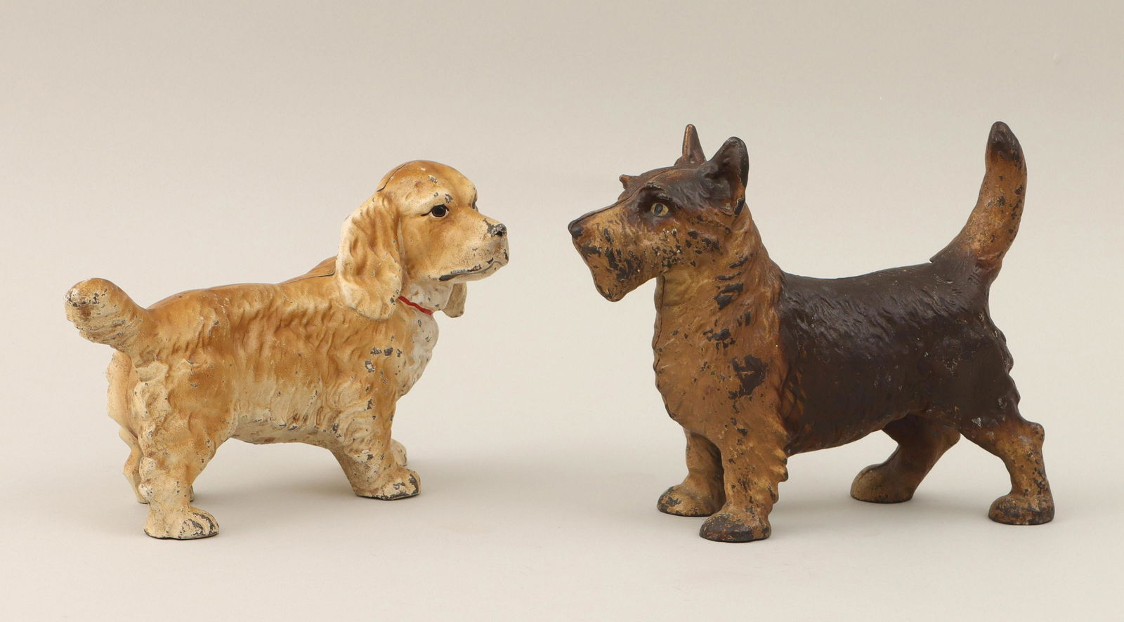 Cast iron dog doorstops: Group of (2) painted cast iron dog doorstops, to include: Scottish terrier; and spaniel. Paint loss to both. Larger (terrier) 8-1/2''h, 10-1/2''w, 3-1/2''d. IMPORTANT SHIPPING INFORMATION 1 - LIVE-SHI