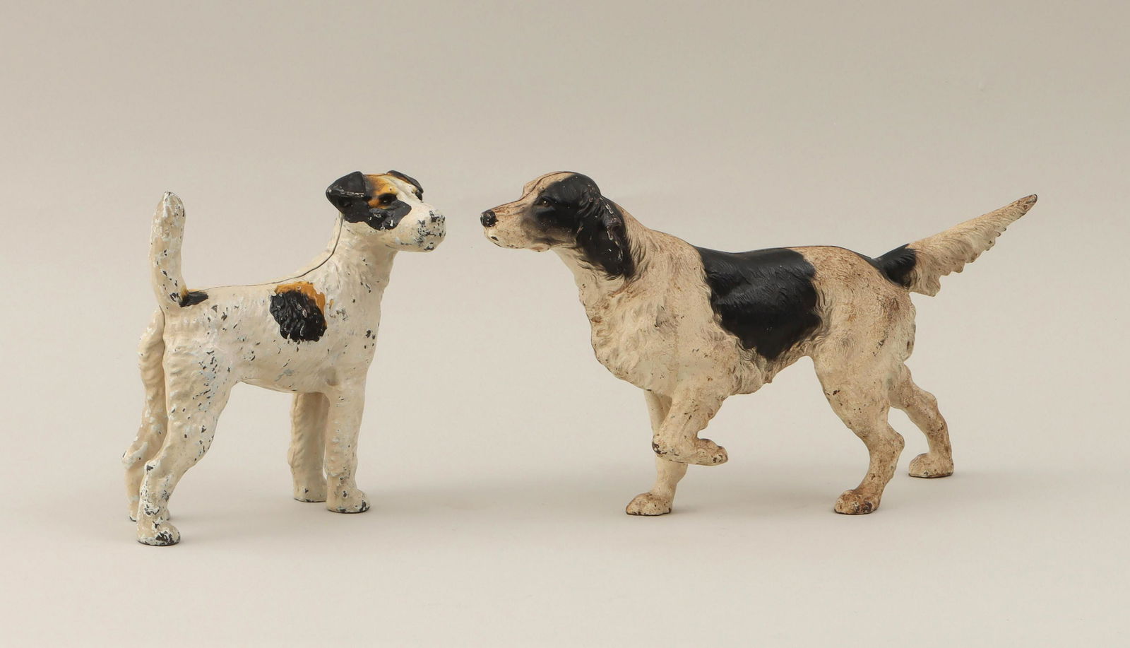 Cast iron dog doorstops: Group of (2) painted cast iron dog doorstops, to include: setter and terrier. Paint loss. Larger (setter) 8-1/2''h, 16''w, 7-1/2''d. IMPORTANT SHIPPING INFORMATION 1 - LIVE-SHIPPING : The service is p