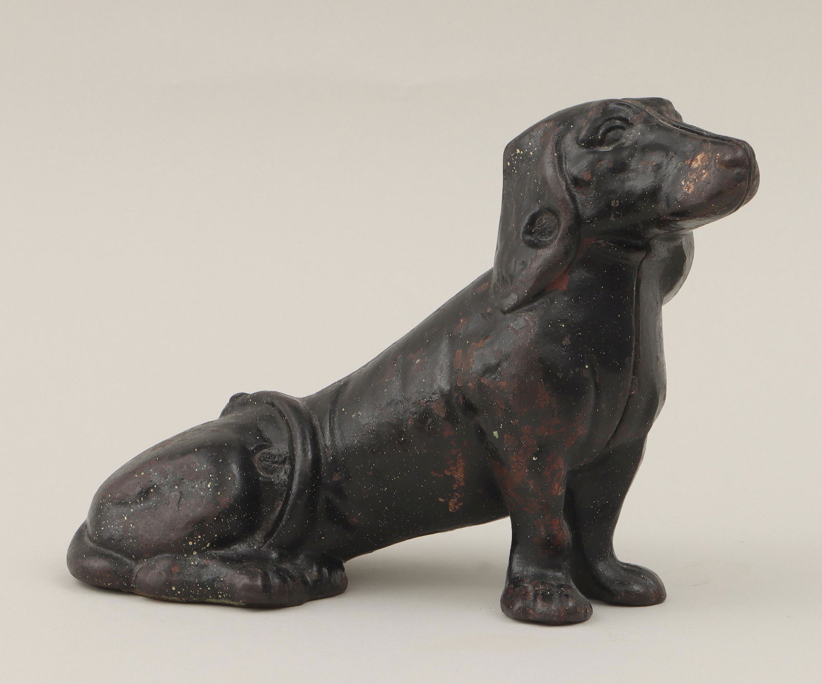 Seated dachshund doorstop: Seated dachshund doorstop, painted cast iron. Some paint loss, oxidation, accretion. 8''h, 11''w, 5-1/2''d. IMPORTANT SHIPPING INFORMATION 1 - LIVE-SHIPPING : The service is provided by Liveauctioneer