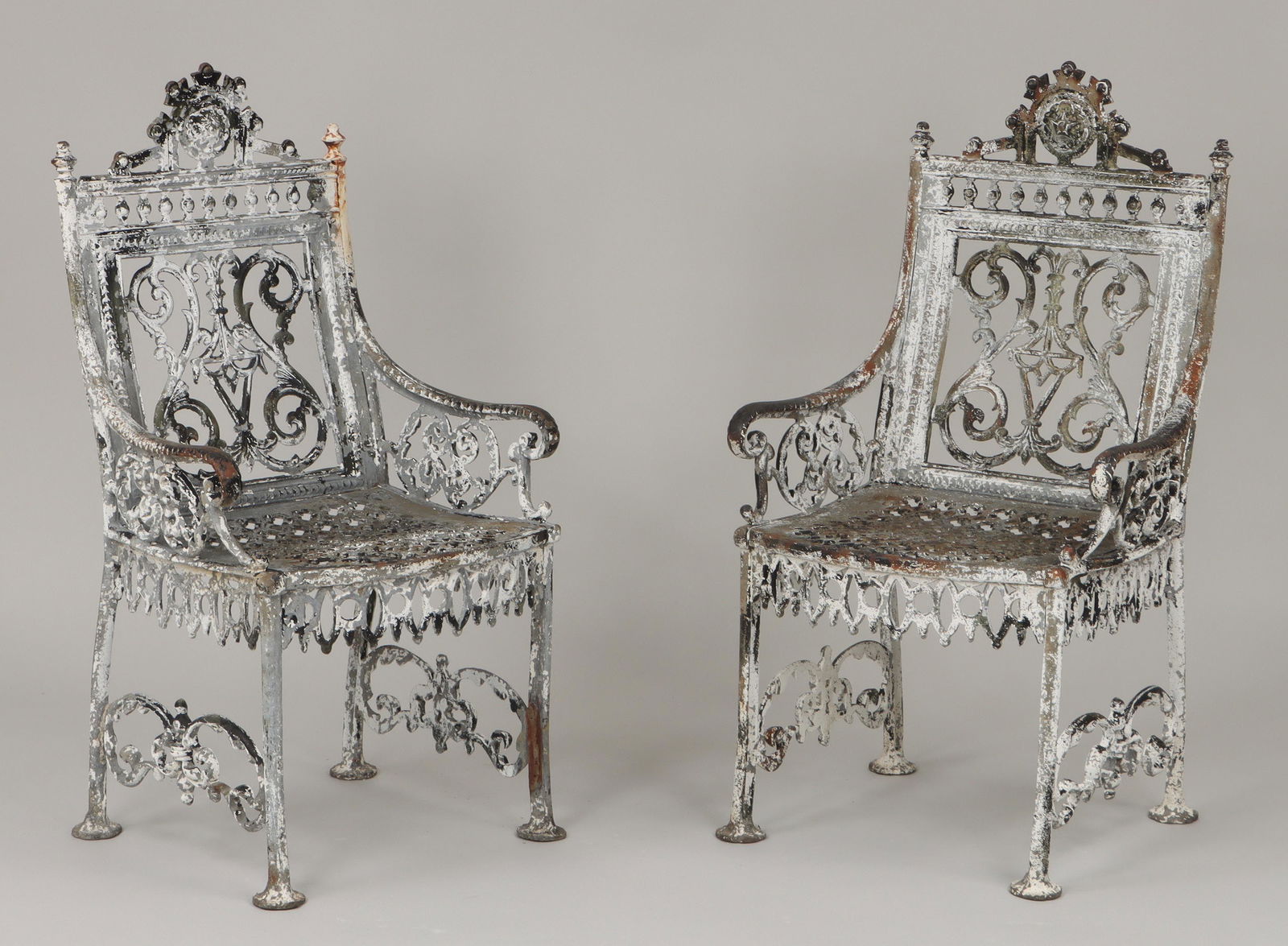 Pair of cast iron John McLean garden armchairs: Pair of cast iron John McLean garden armchairs, 19th/20th century, New York, each with half-round label to back. Paint loss, one back leg with break. 38''h, 21''w, 19-1/2''d. IMPORTANT SHIPPING INFORM