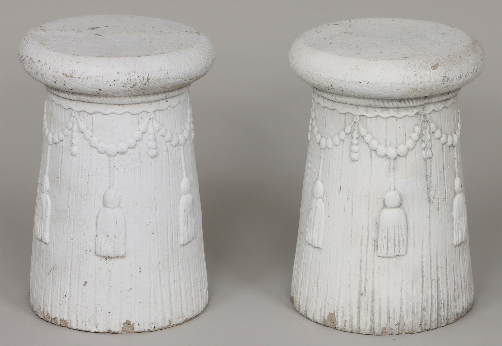 Pair of cast stone garden seats: Pair of cast stone garden seats with tassel relief decoration, painted white. Wear from use, minor chips around base. 17-1/2''h. IMPORTANT SHIPPING INFORMATION 1 - LIVE-SHIPPING : The service is provi