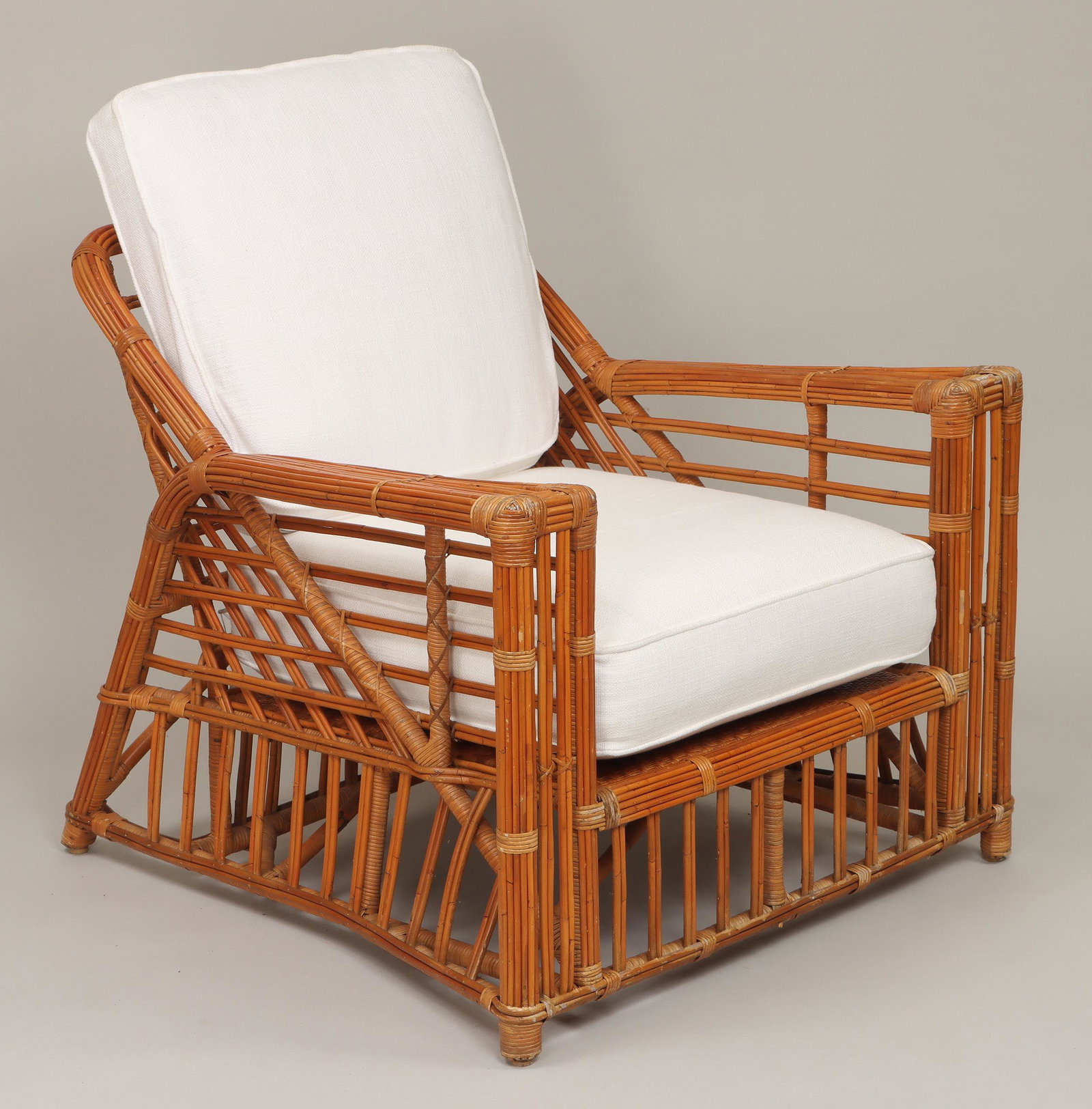 Rattan and bamboo lounge armchair: Rattan and bamboo lounge armchair, with white canvas cushions. Minor wear from use. 32''h, 35-1/4''w, 37-1/4''d. Provenance: purchased by the present owner from Ralph Lauren Showroom in the Hamptons. 