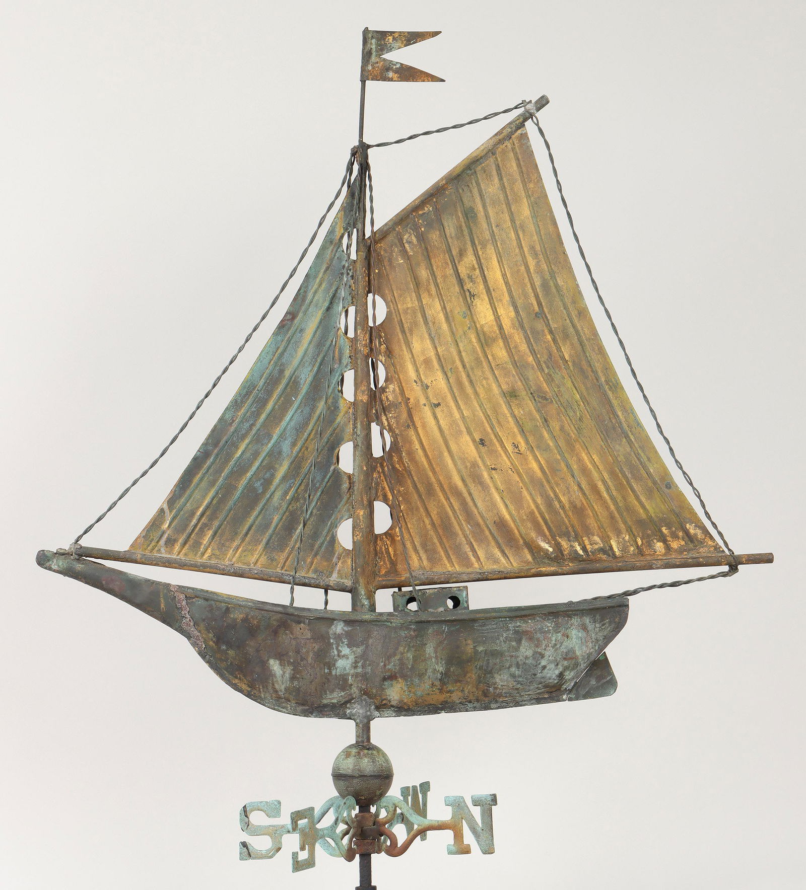 American sailboat weathervane: American folk art full-bodied molded sheet copper sailboat weathervane with gilded sails and cast iron verdigris patinated directionals. 34-1/2''h, 12''w, 30-1/2''l. Provenance: Estate of Joseph ''Jay